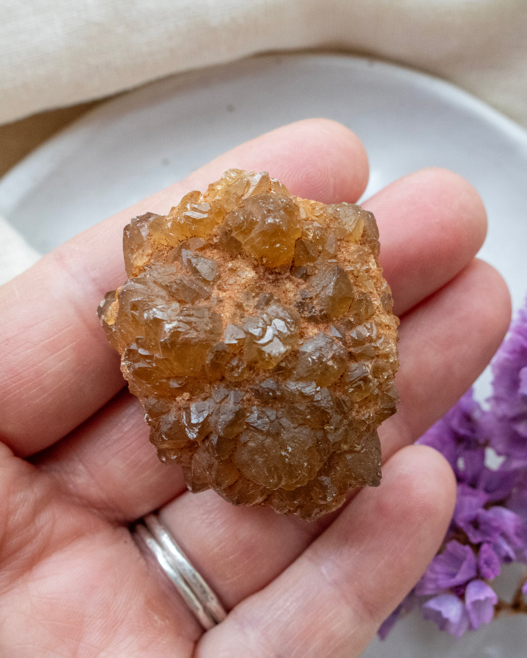 Hand holding a large crystal with a blurred background