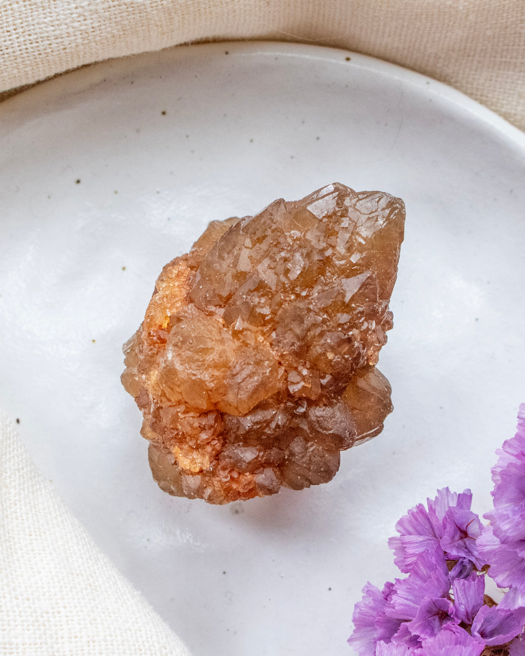 Crystal on a white plate with purple flowers