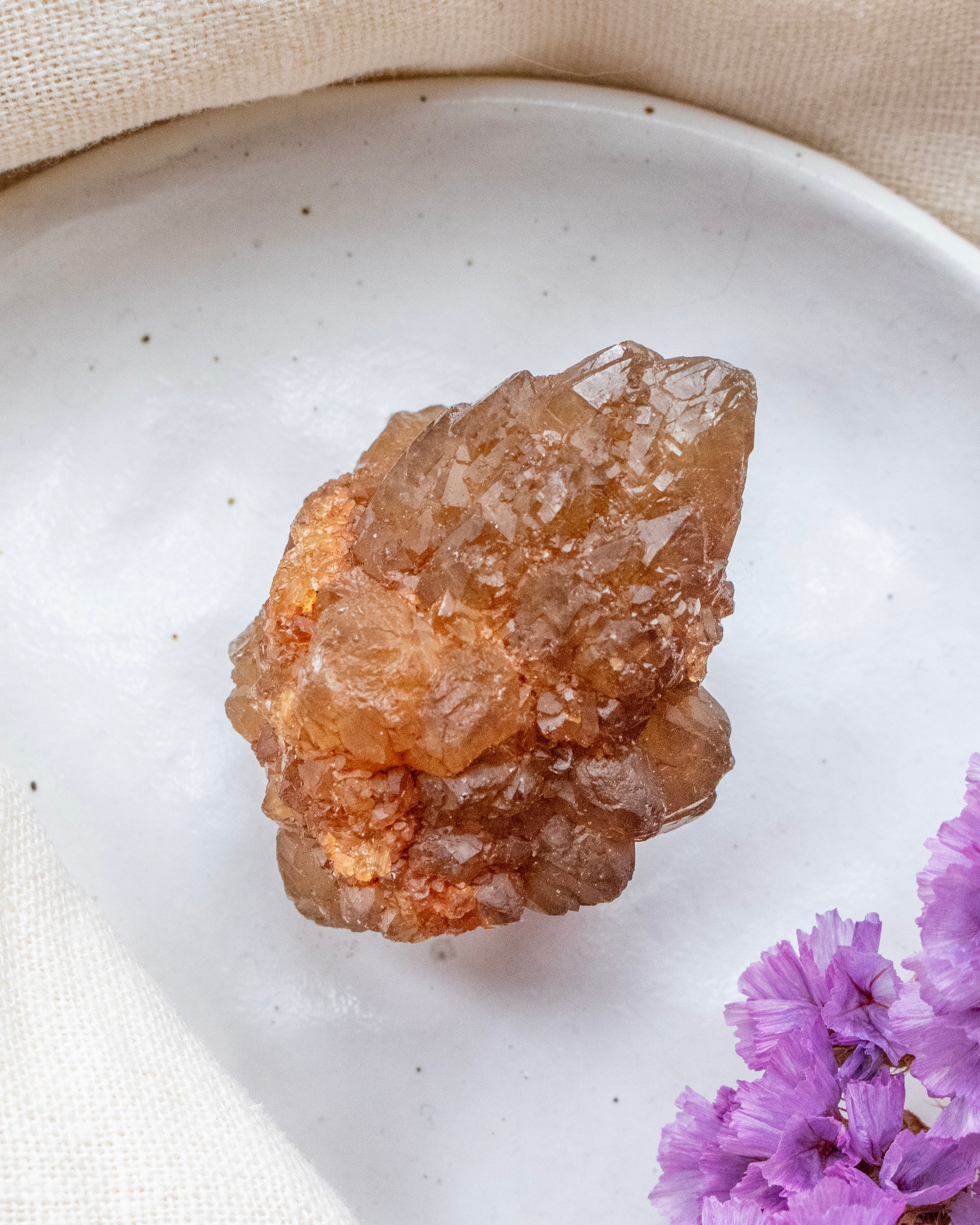 Crystal on a white plate with purple flowers