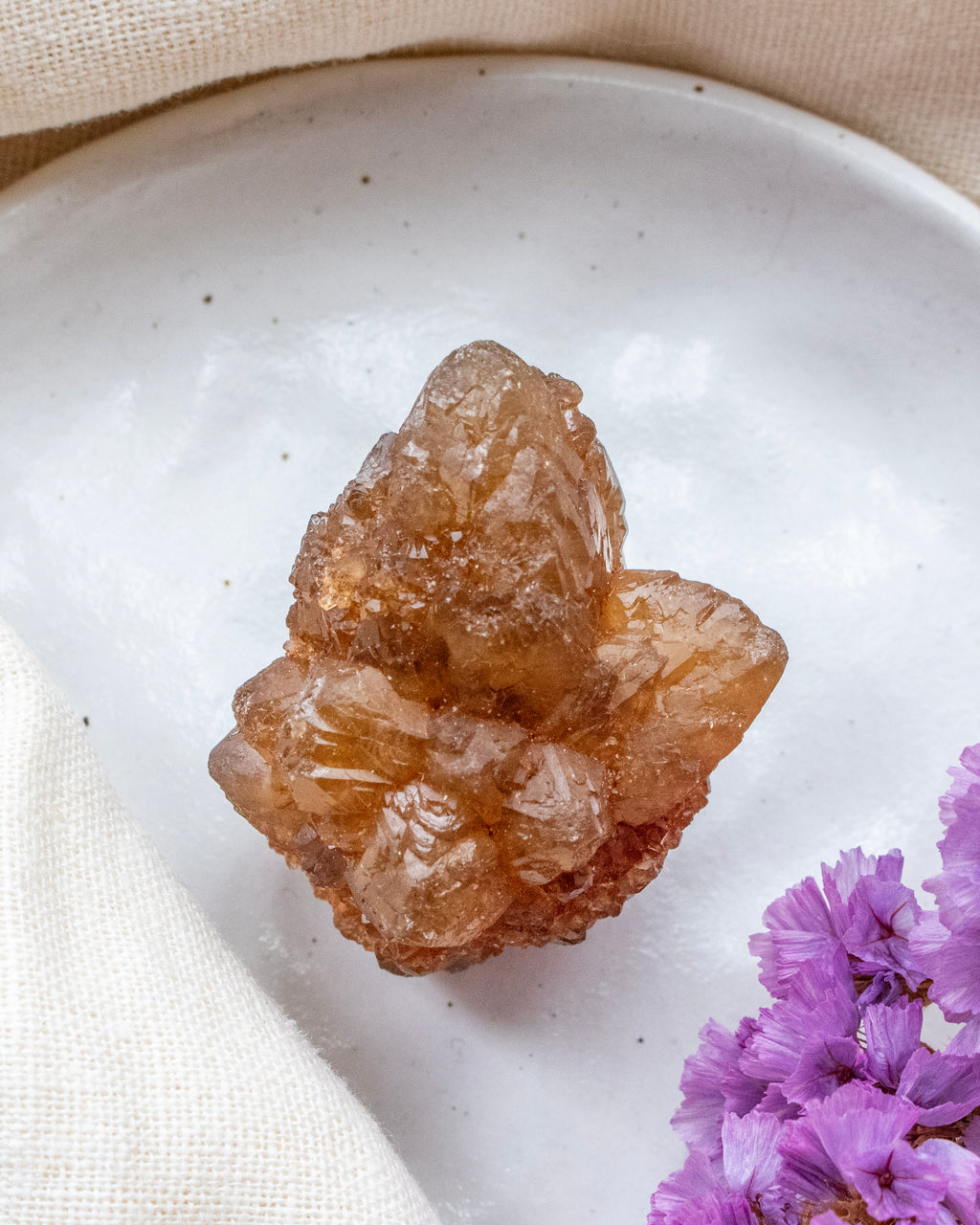 Crystal rock on a white plate with purple flowers
