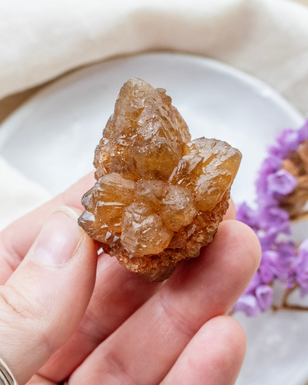 Hand holding a crystal rock with a blurred background