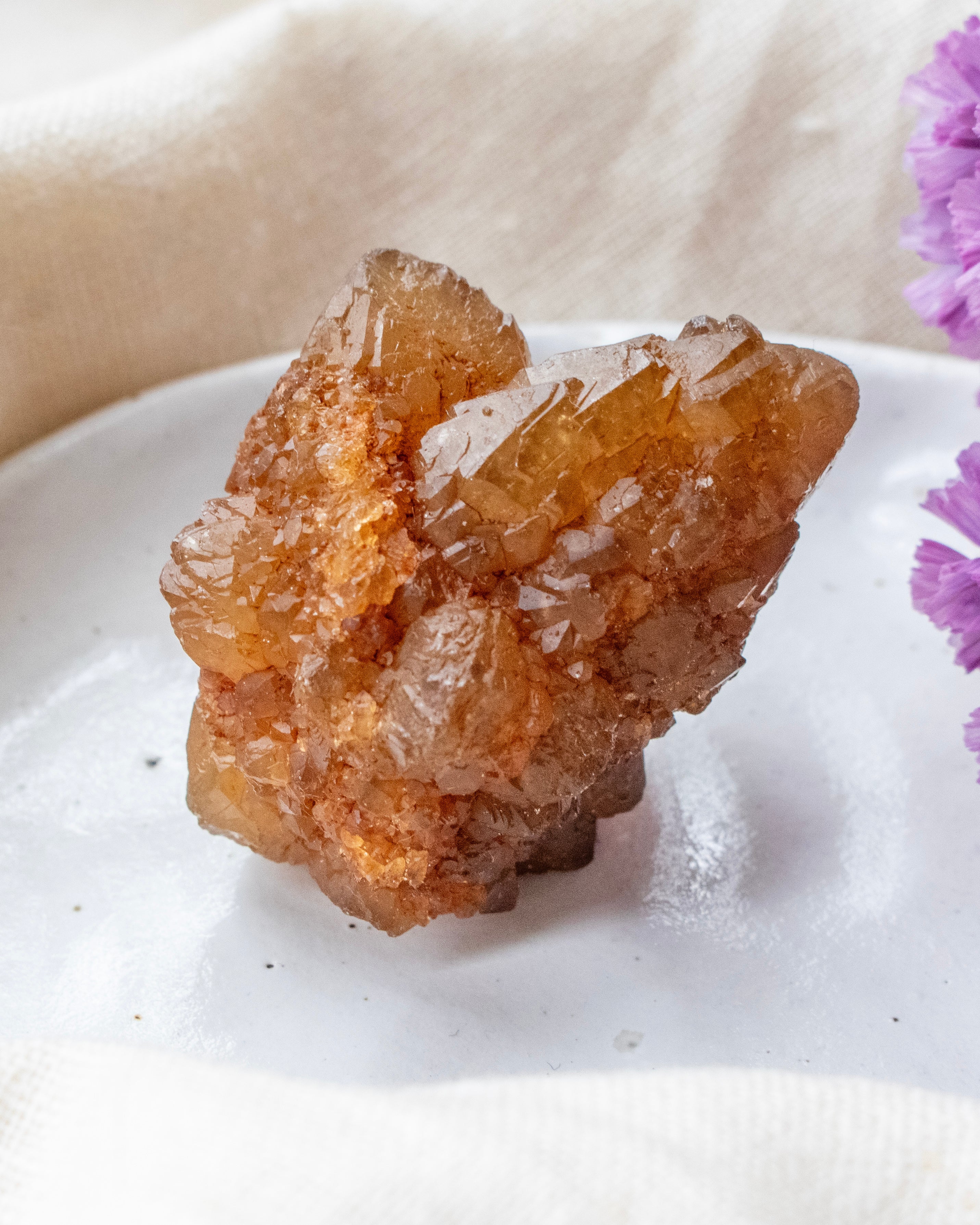 Brown crystal on a white surface with a blurred background