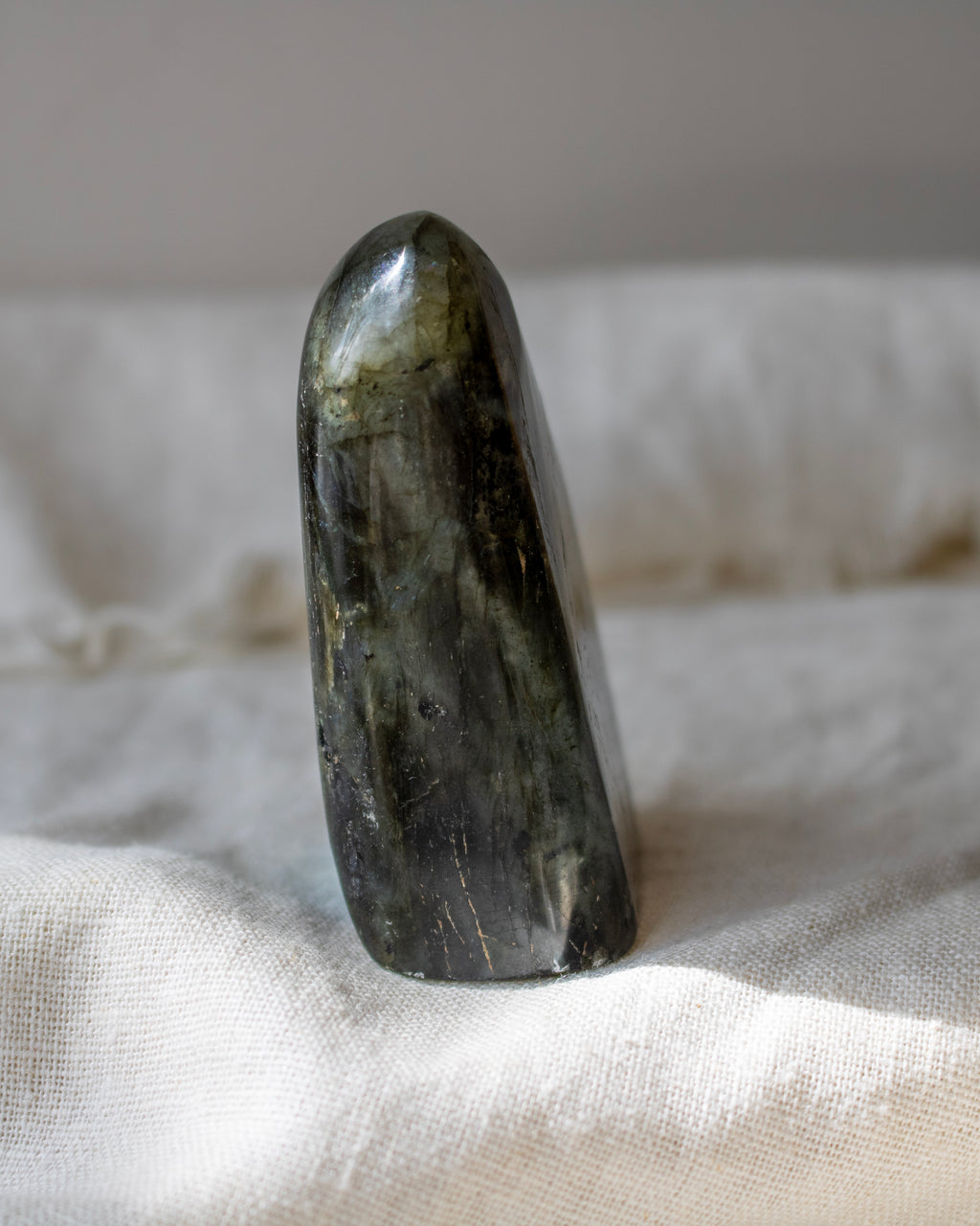 Polished green stone on a textured beige surface