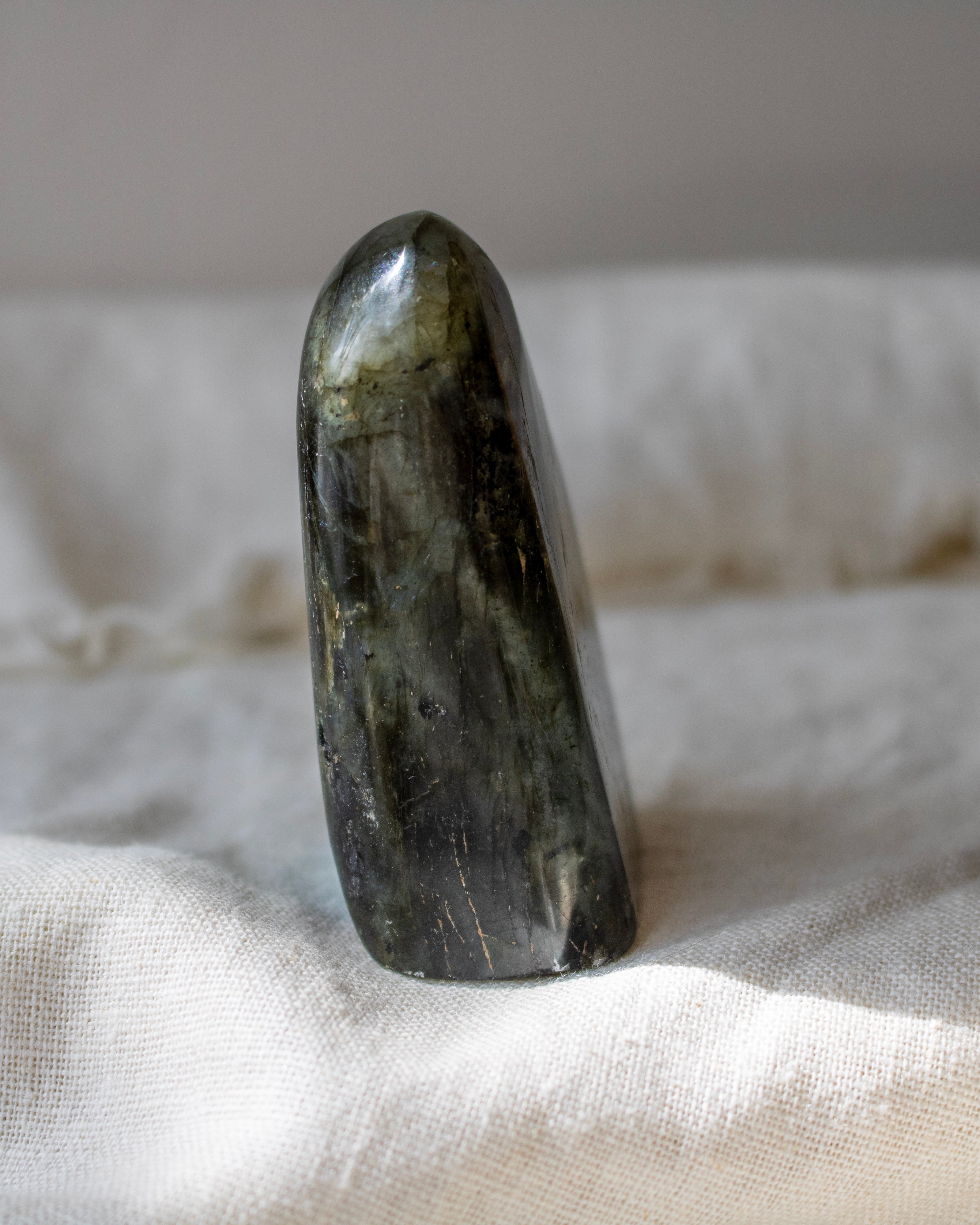 Polished green stone on a textured beige surface
