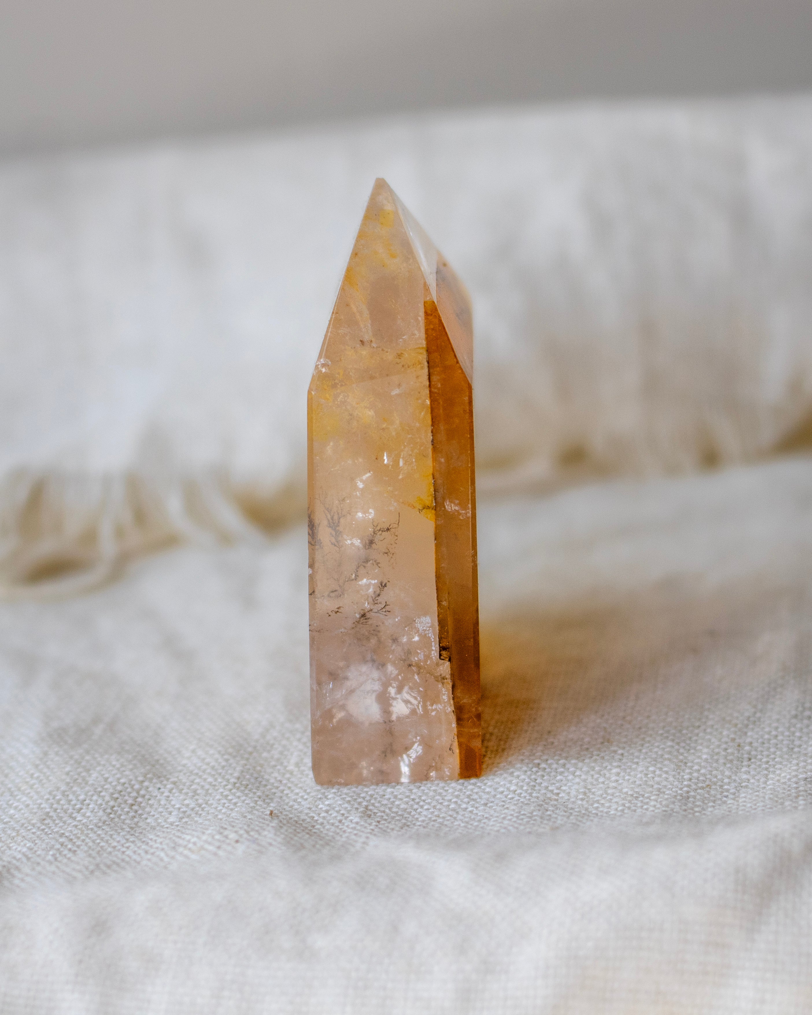 Clear crystal tower on a textured white fabric background