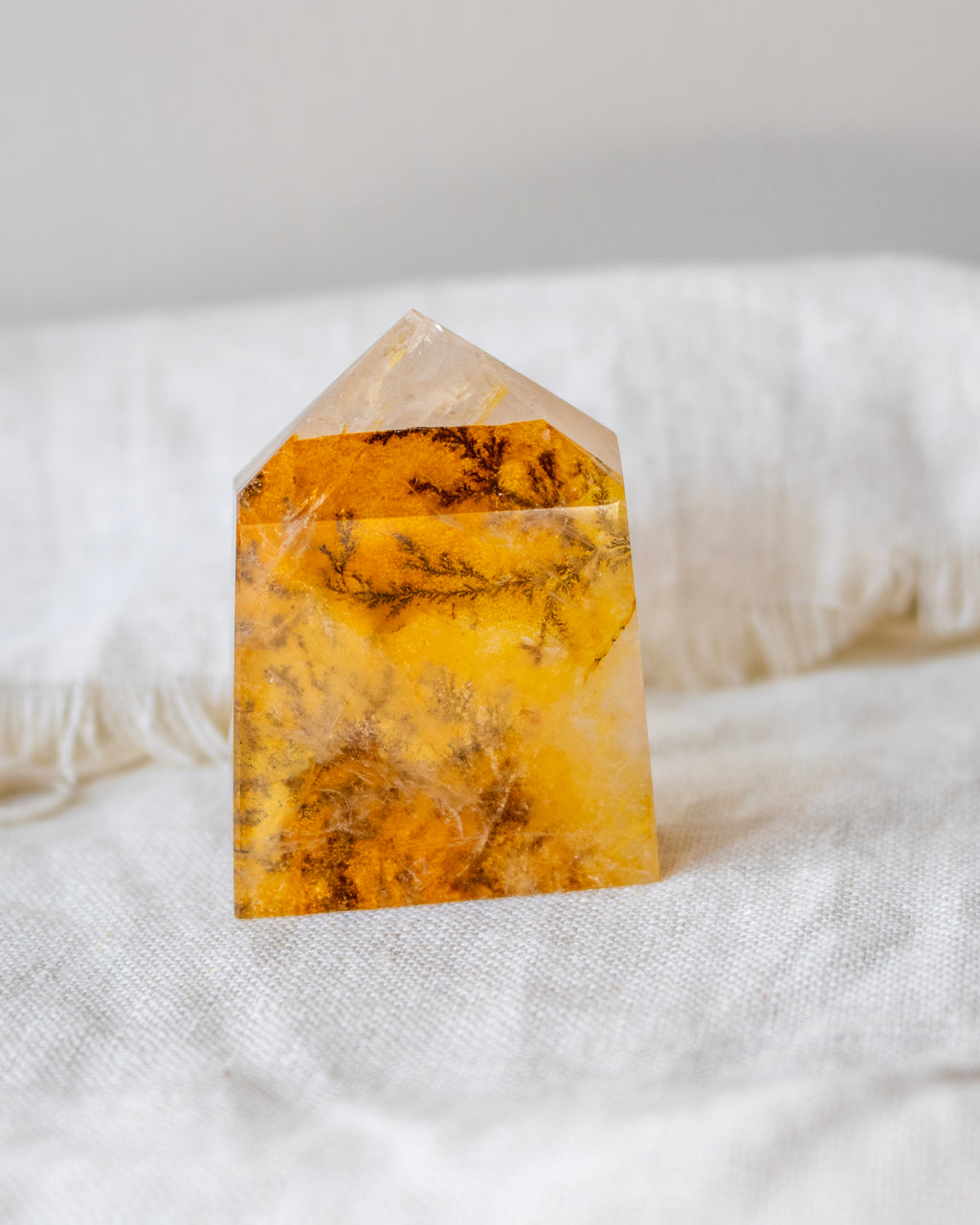 Yellow crystal tower on a white fabric background