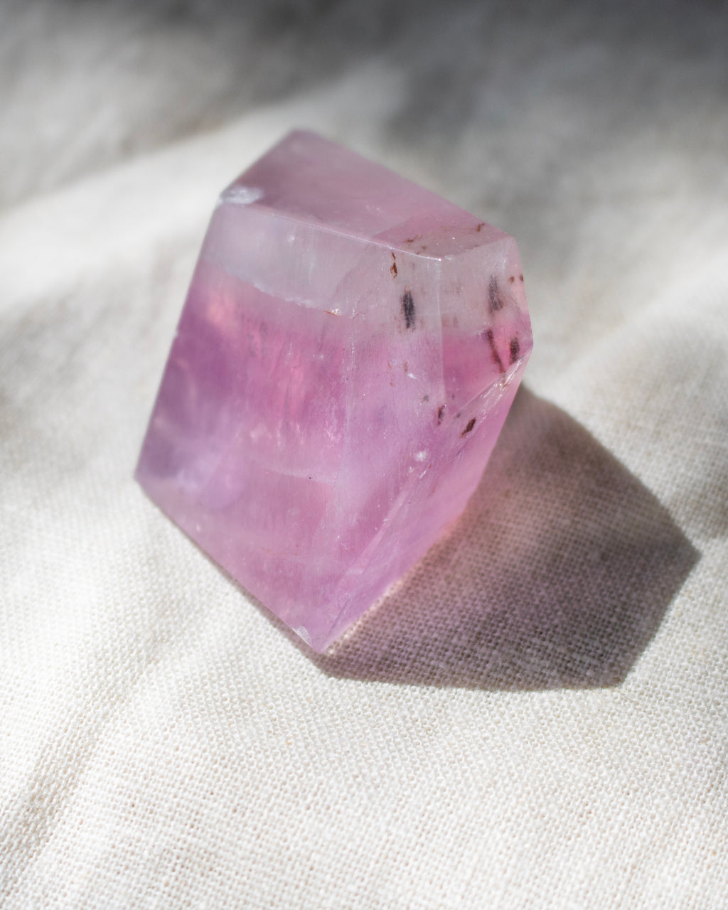 Pink crystal on a textured white surface