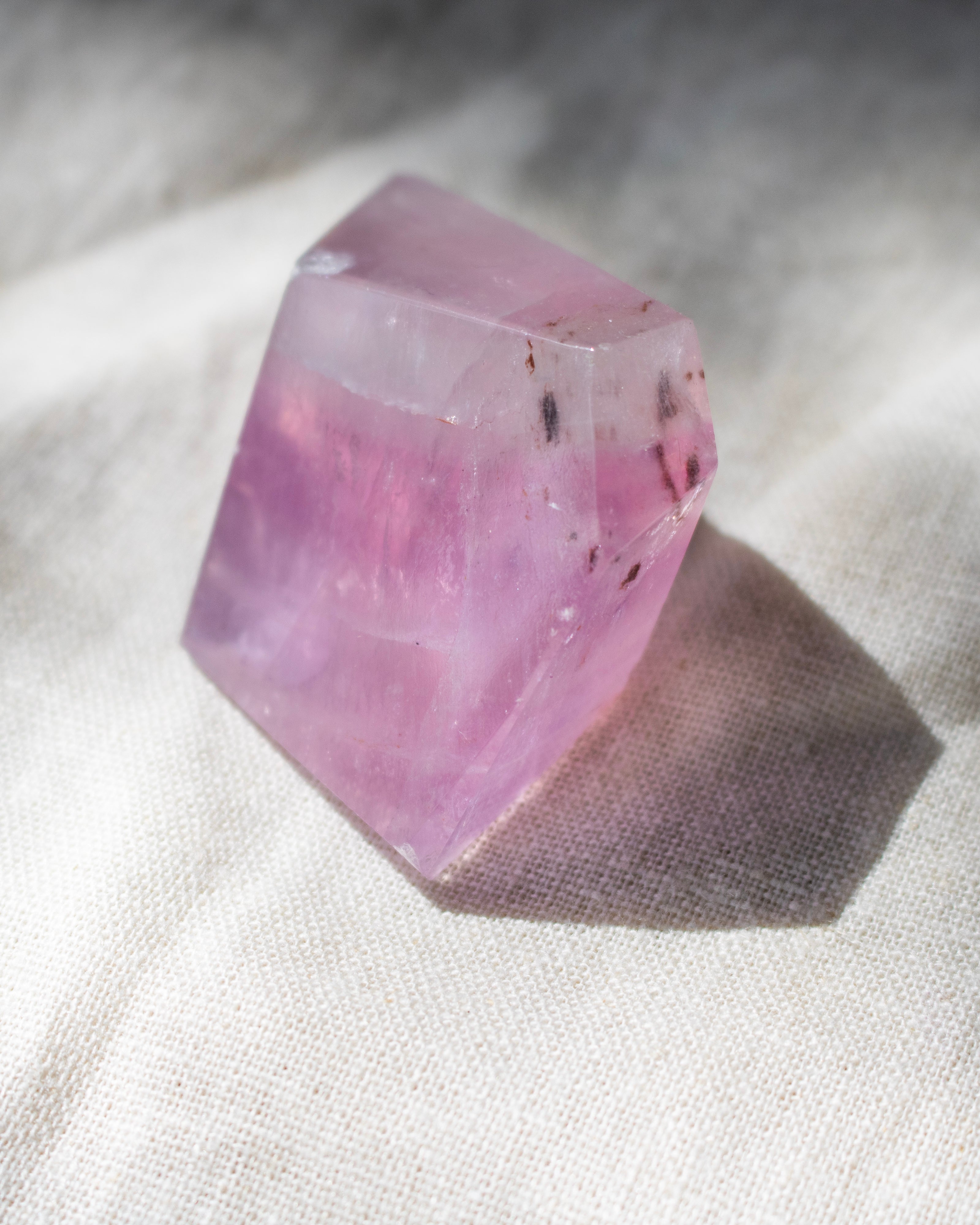 Pink crystal on a textured white surface
