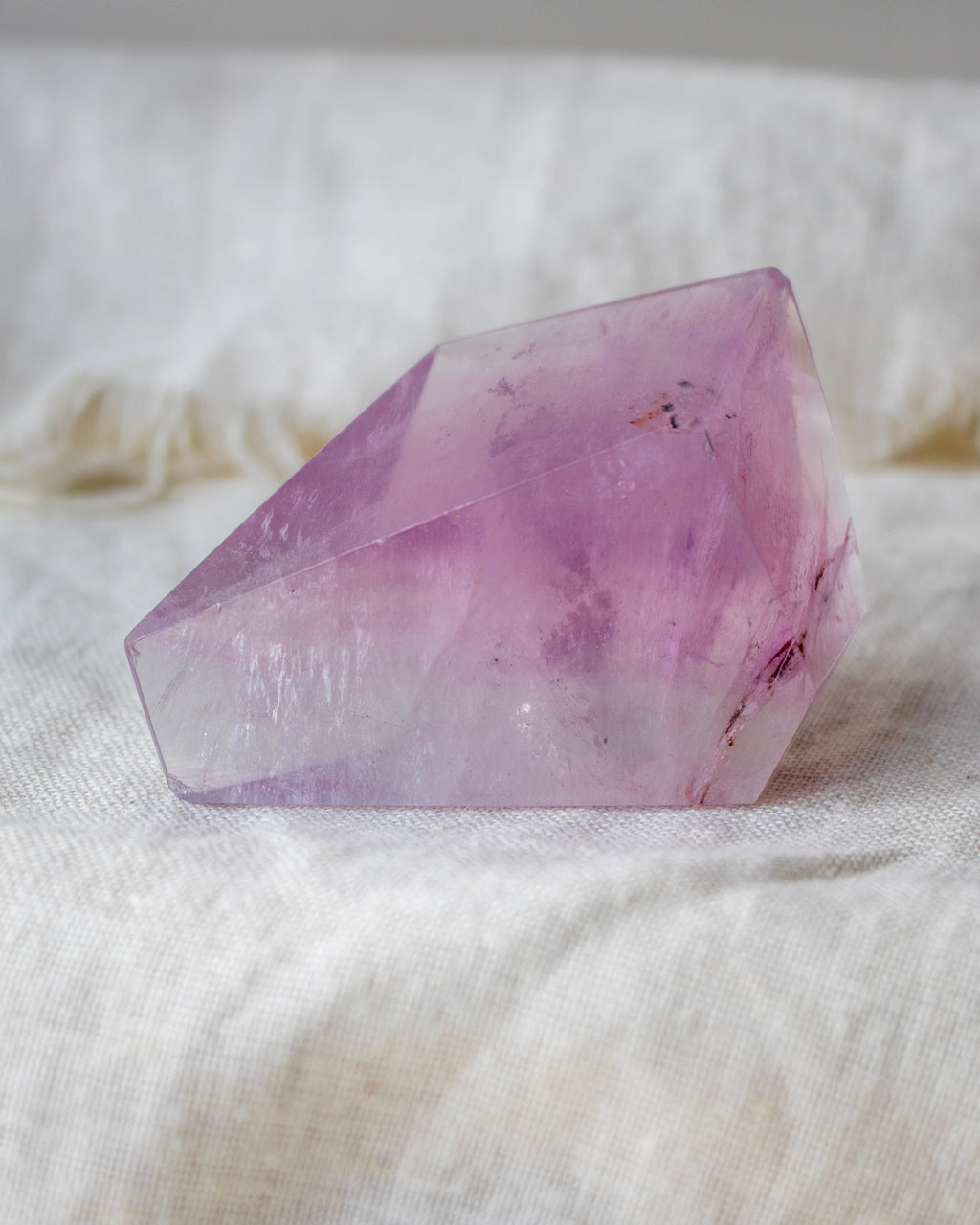 Purple crystal on a white fabric background
