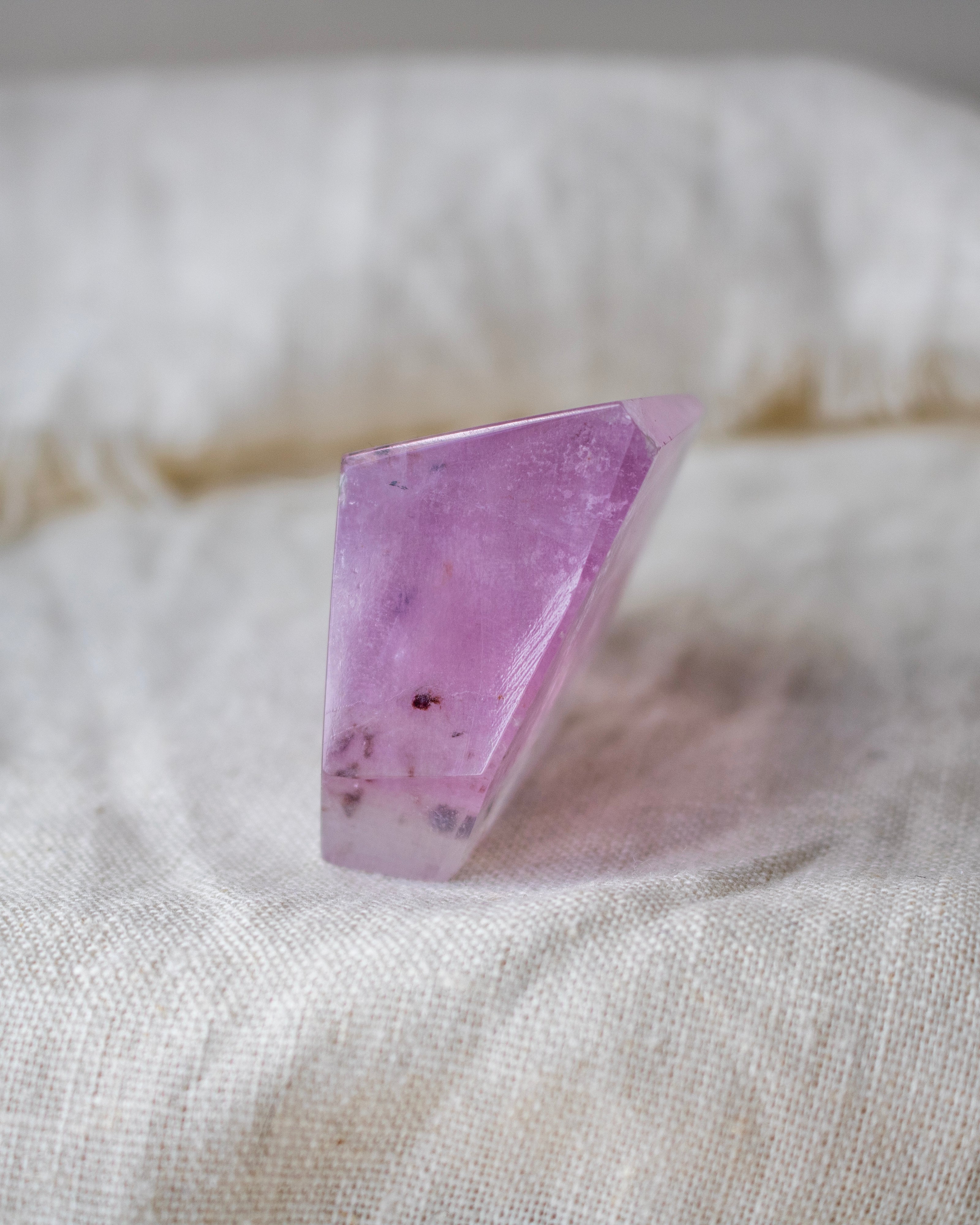 Purple crystal on a textured beige surface