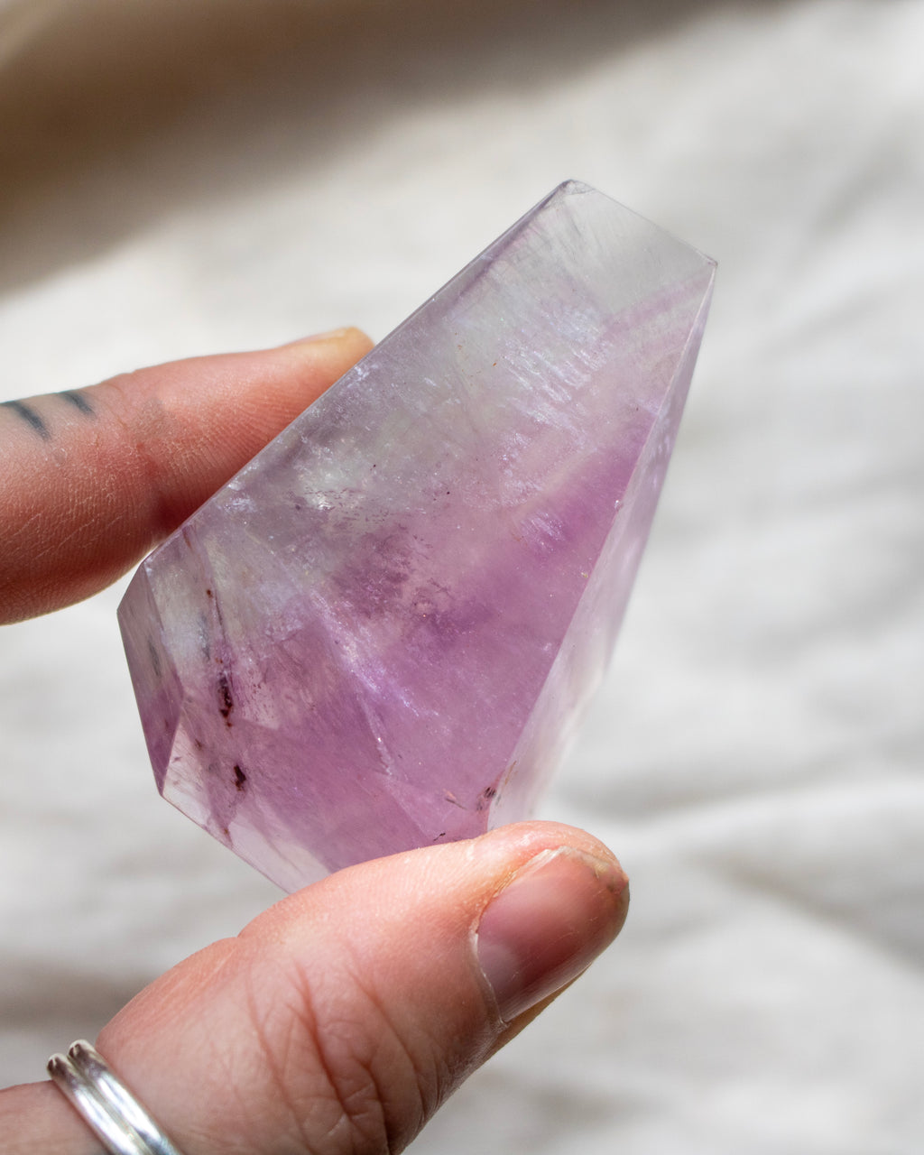 Person holding a purple crystal with a blurred background