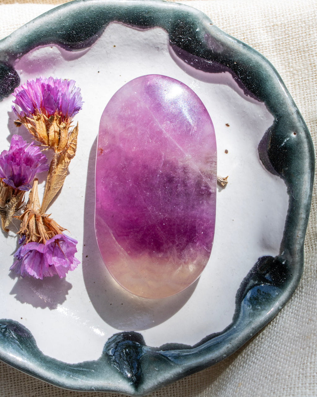 Purple crystal on a decorative plate with dried flowers