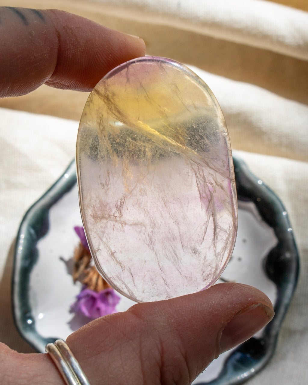 Hand holding a colorful crystal stone with a blurred background