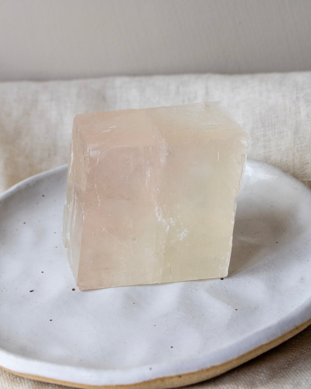 Stone cube on a white ceramic plate with a neutral background