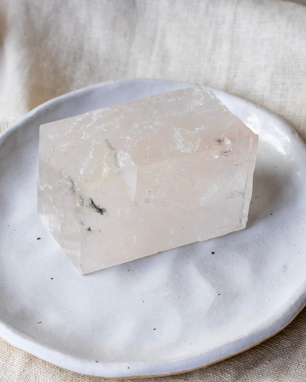 Crystal cube on a white plate with a neutral background
