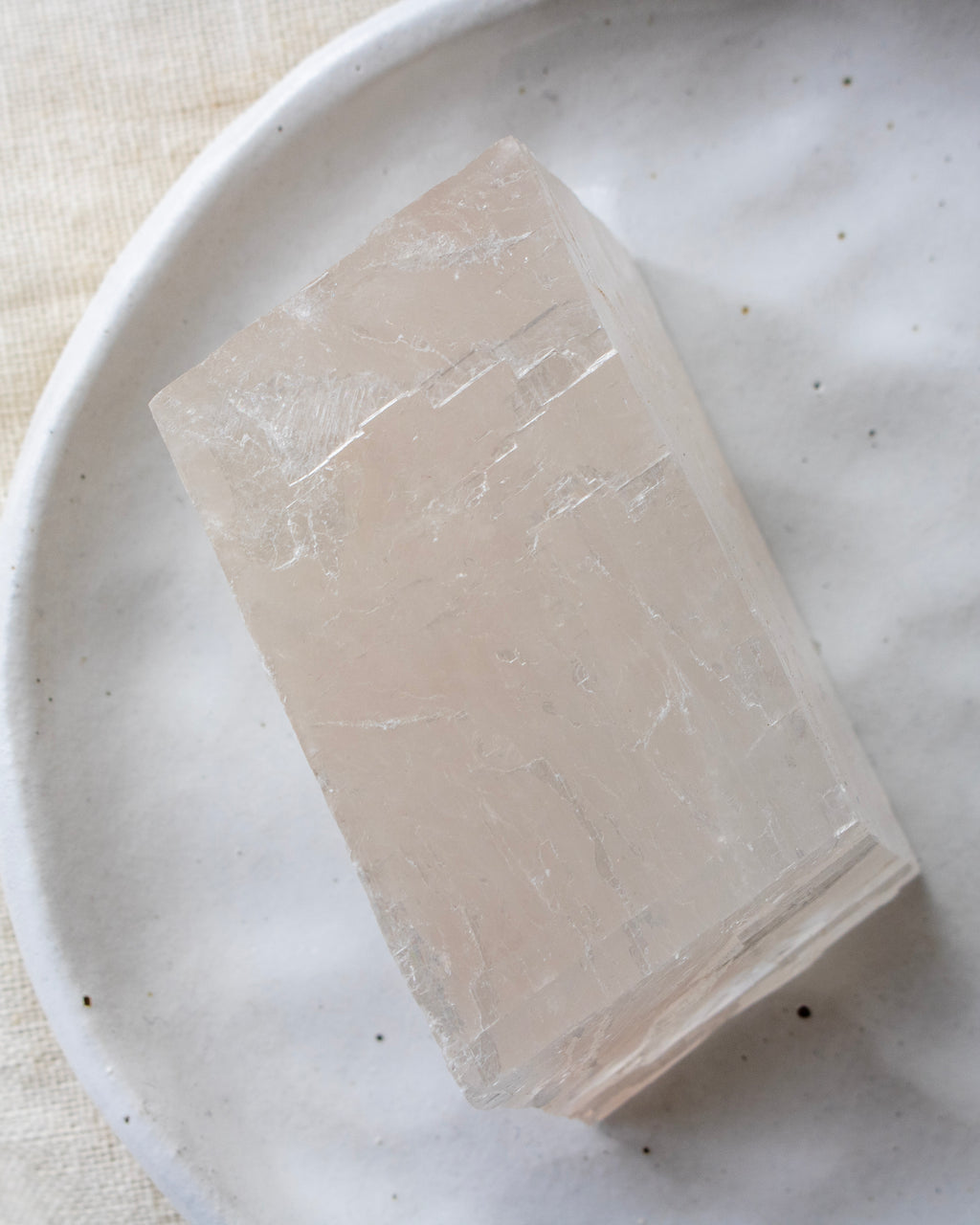 Crystal cube on a white plate with a light background