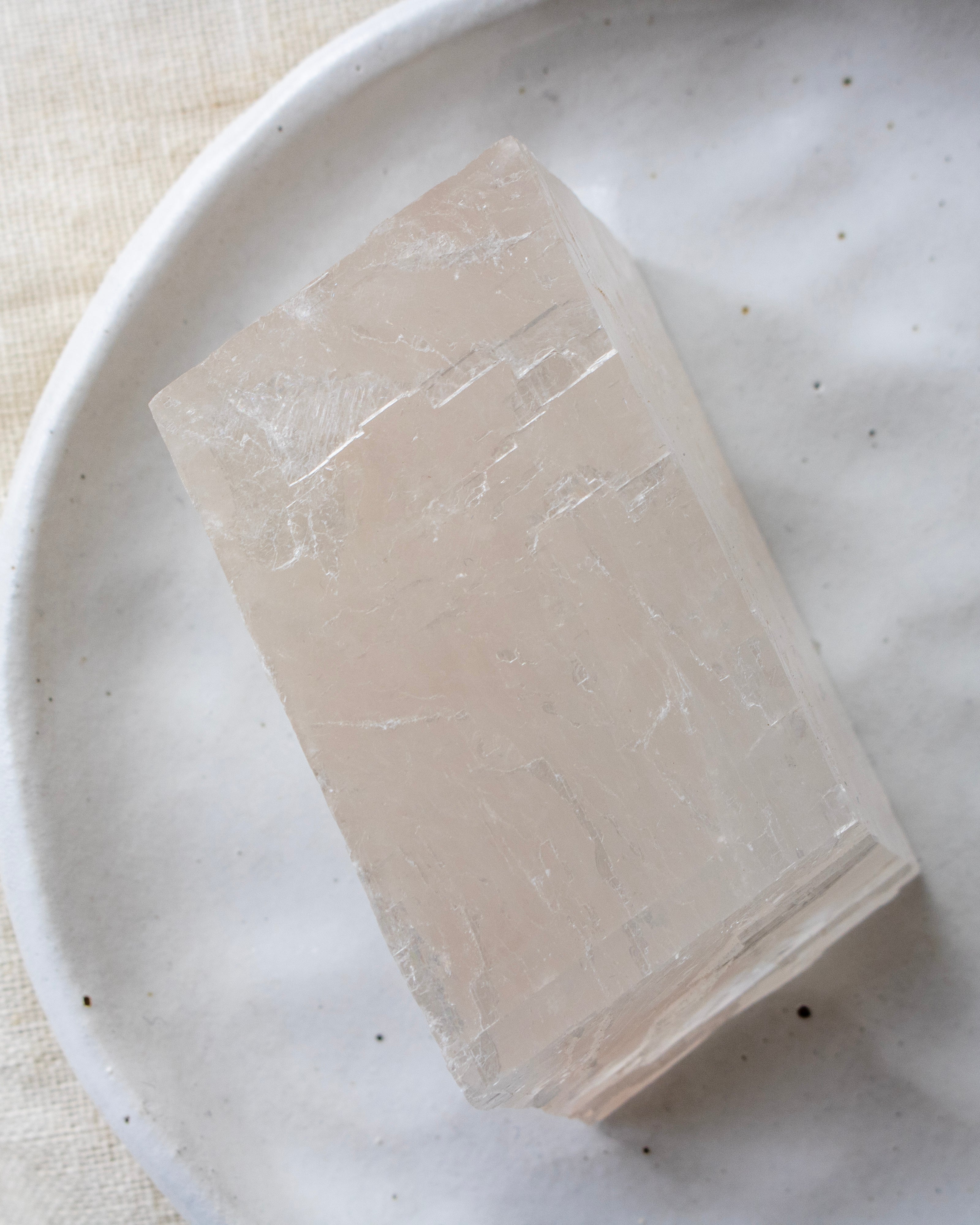 Crystal cube on a white plate with a light background