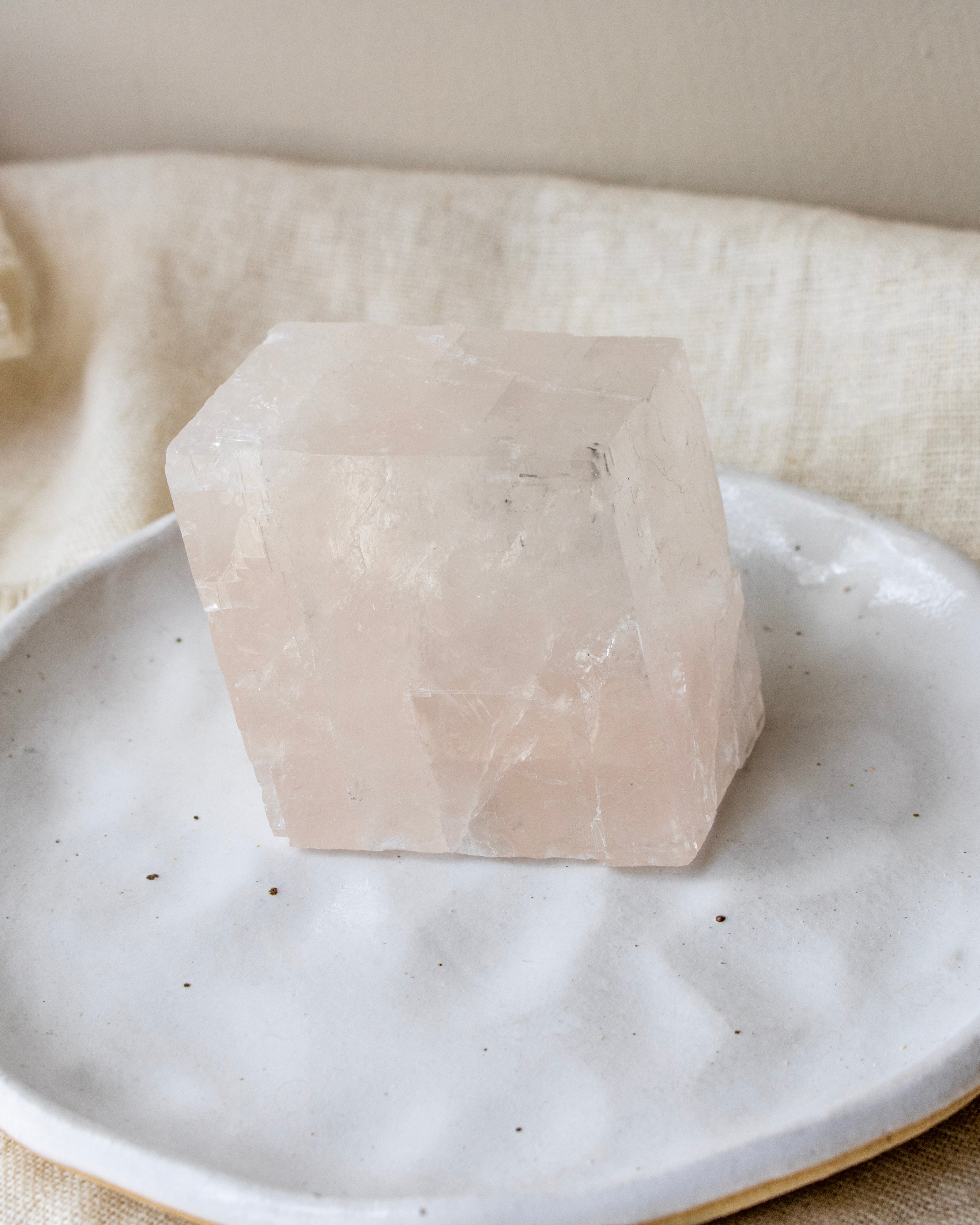 Cuboid crystal on a white plate with a neutral background