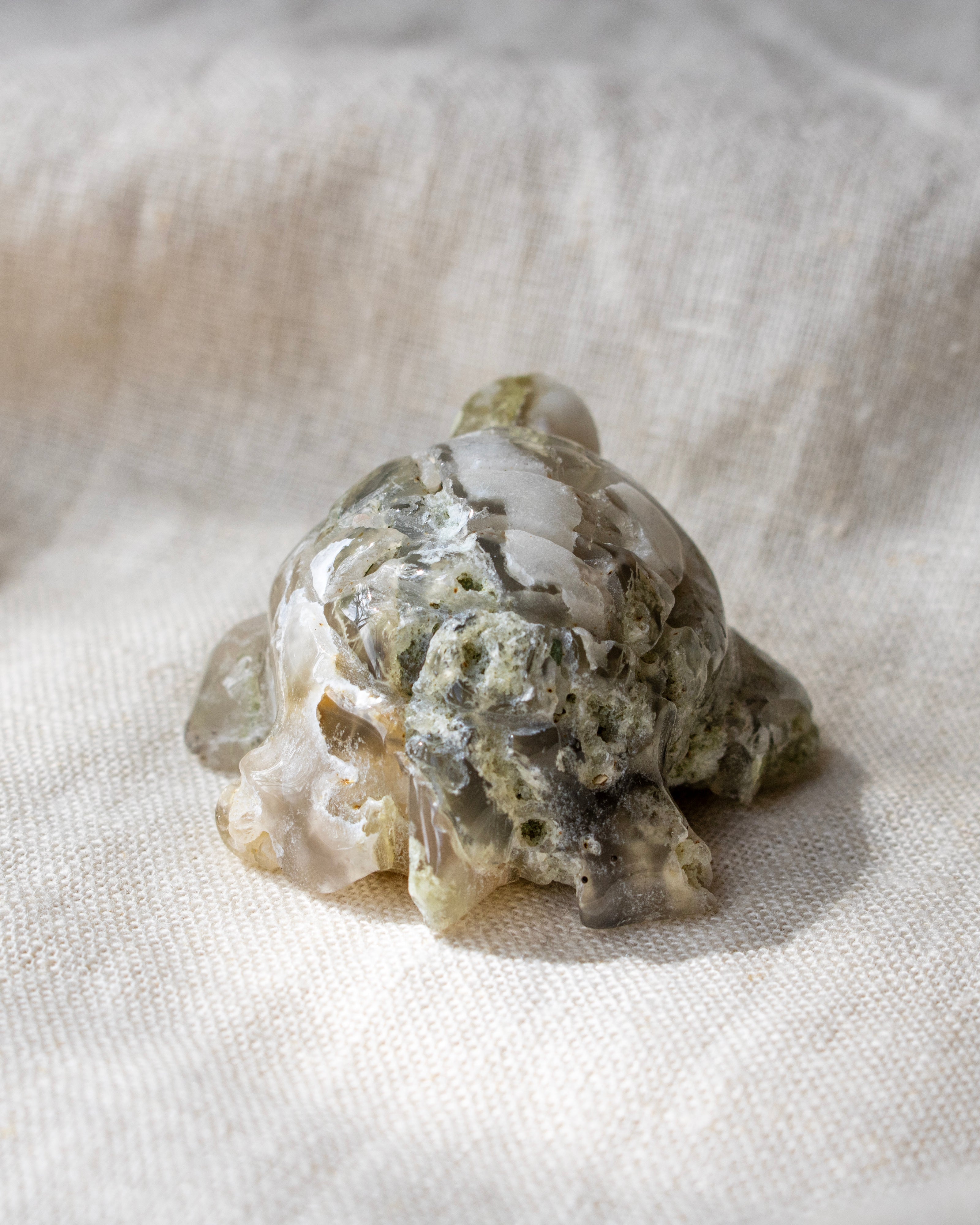 Decorative stone turtle on a textured fabric background
