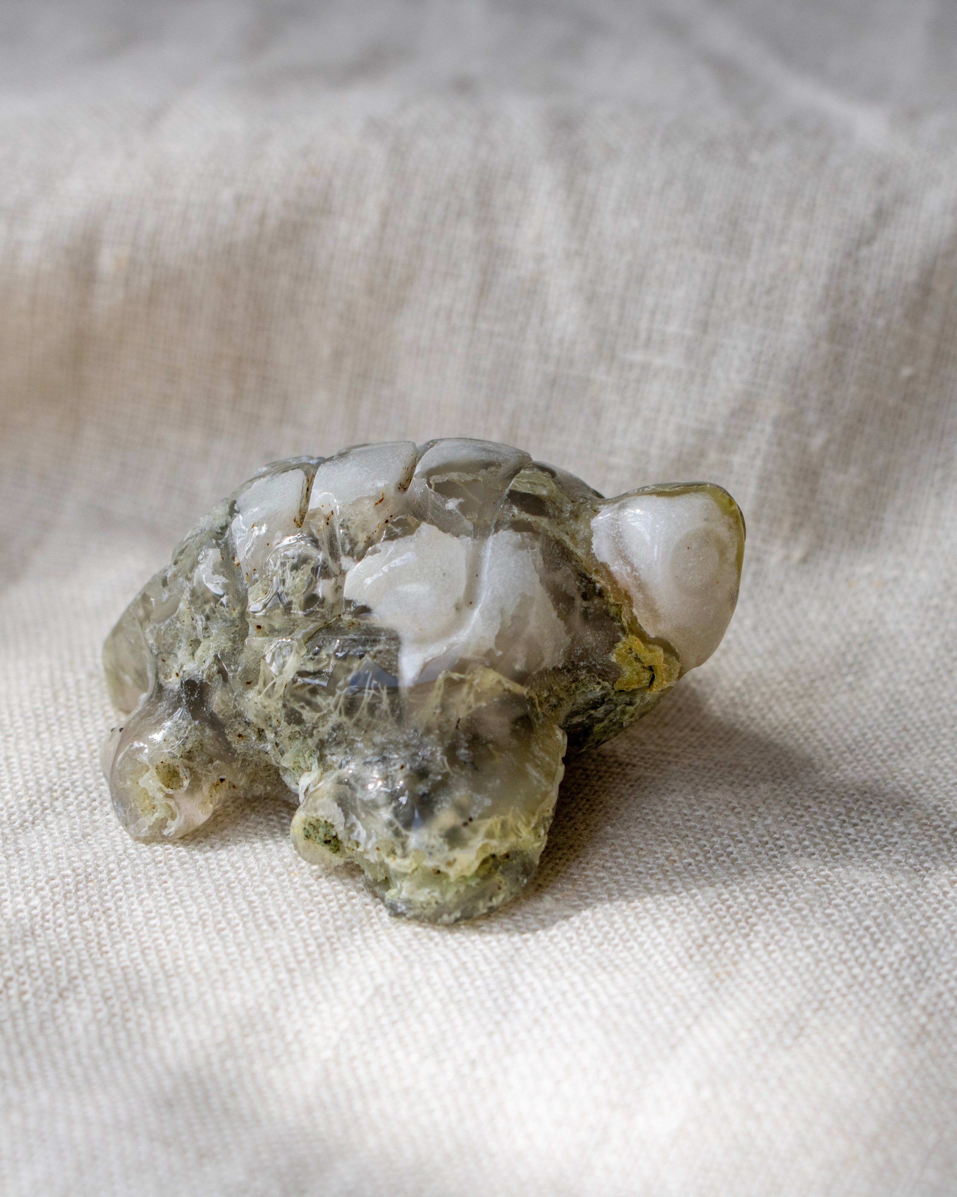 Carved stone turtle figurine on a textured fabric background
