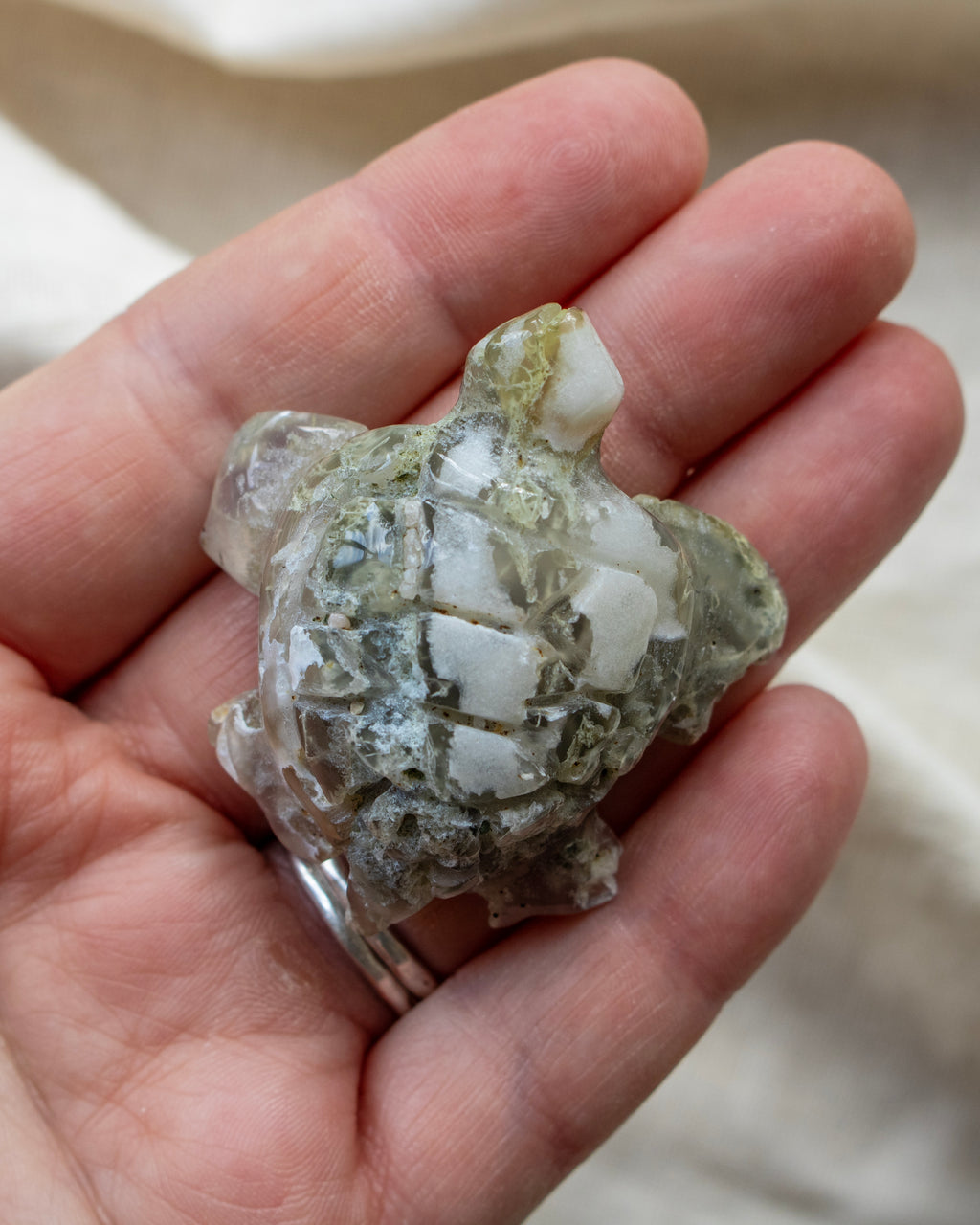 Hand holding a piece of crystal rock with a blurred background