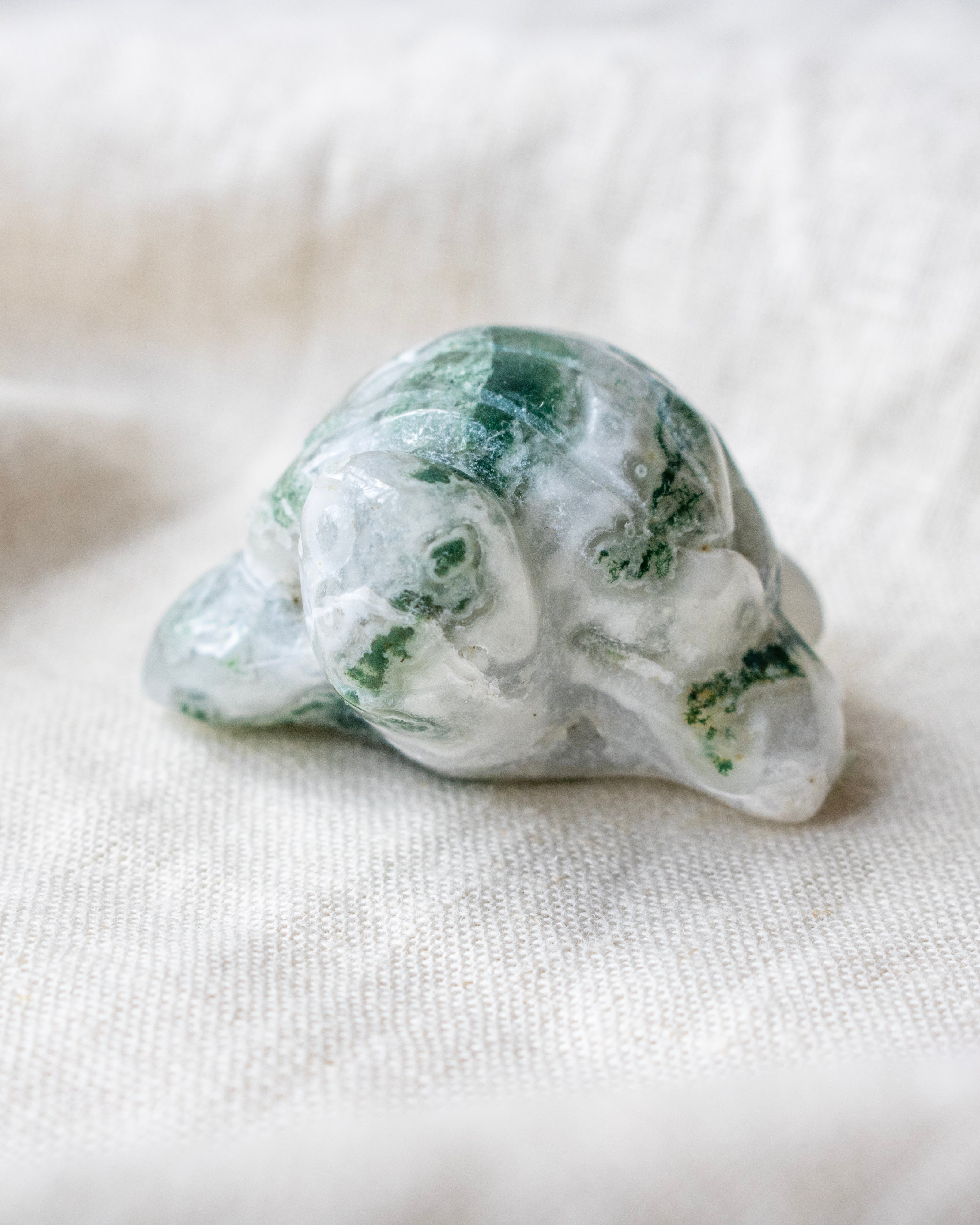 Green and white crystal on a beige fabric background