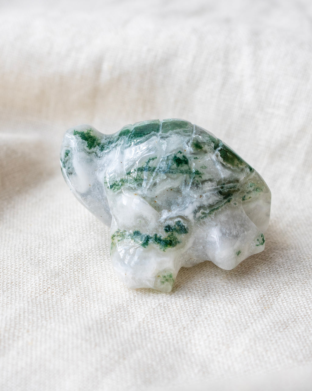Green and white crystal on a white fabric background