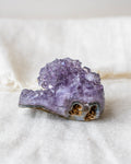 Amethyst crystal cluster on a white fabric background