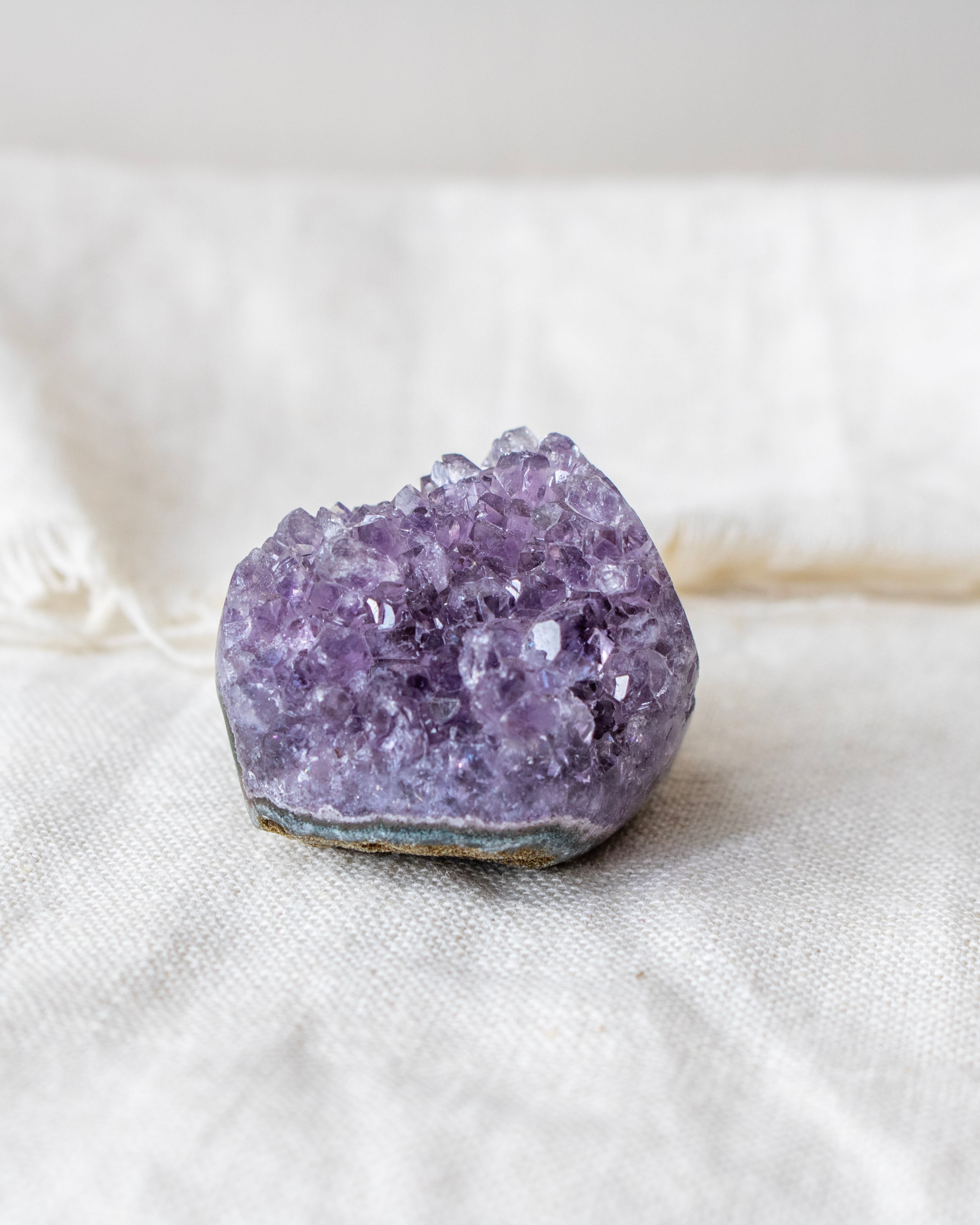 Purple crystal on a white fabric background