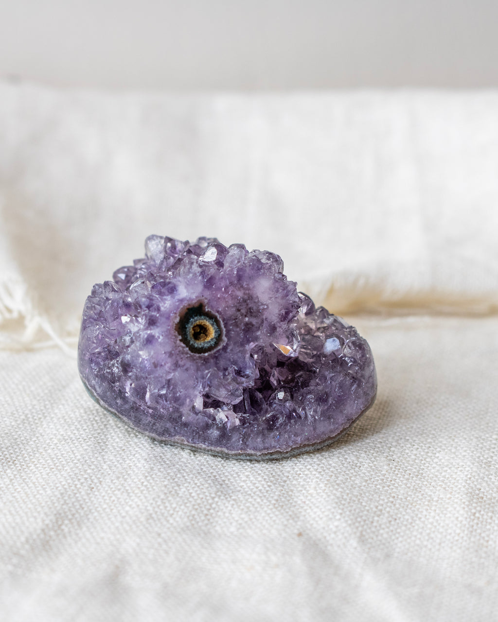 Amethyst crystal on a white fabric background