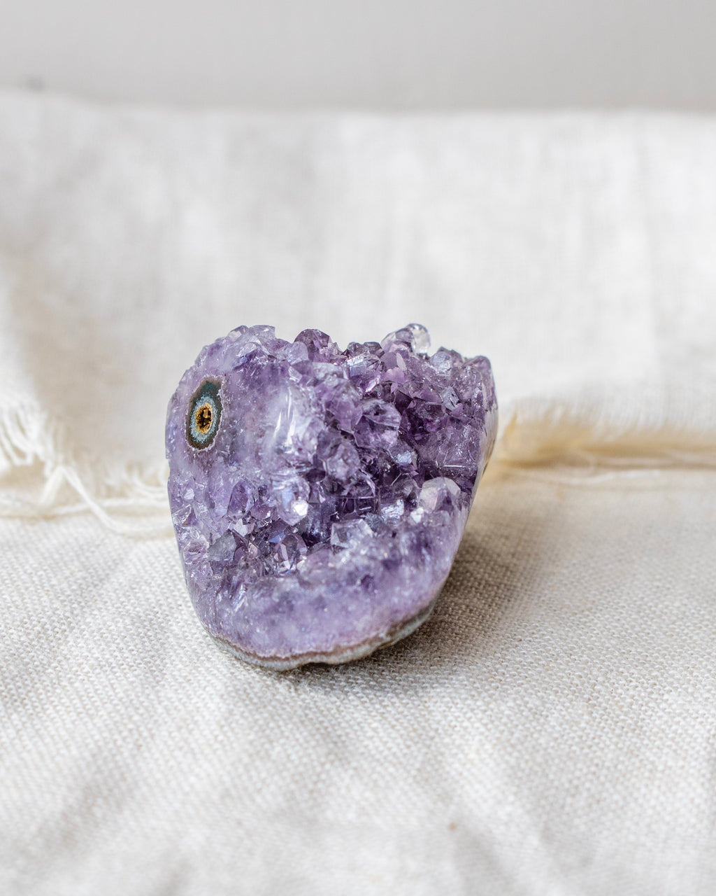 Amethyst crystal on a white fabric background