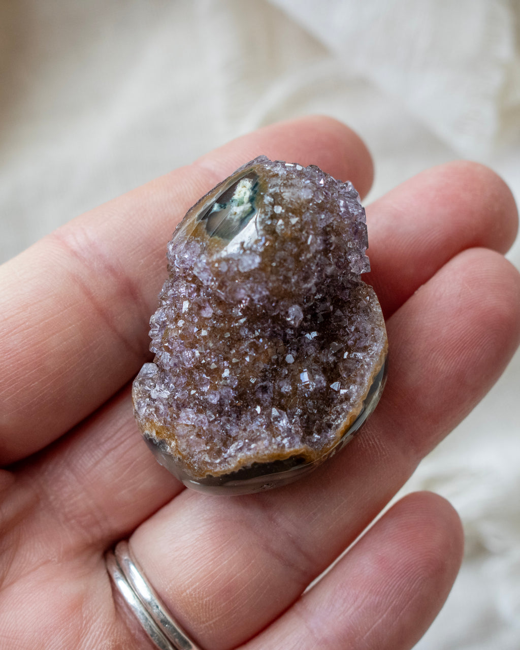 Geode crystal held in a hand with a blurred background
