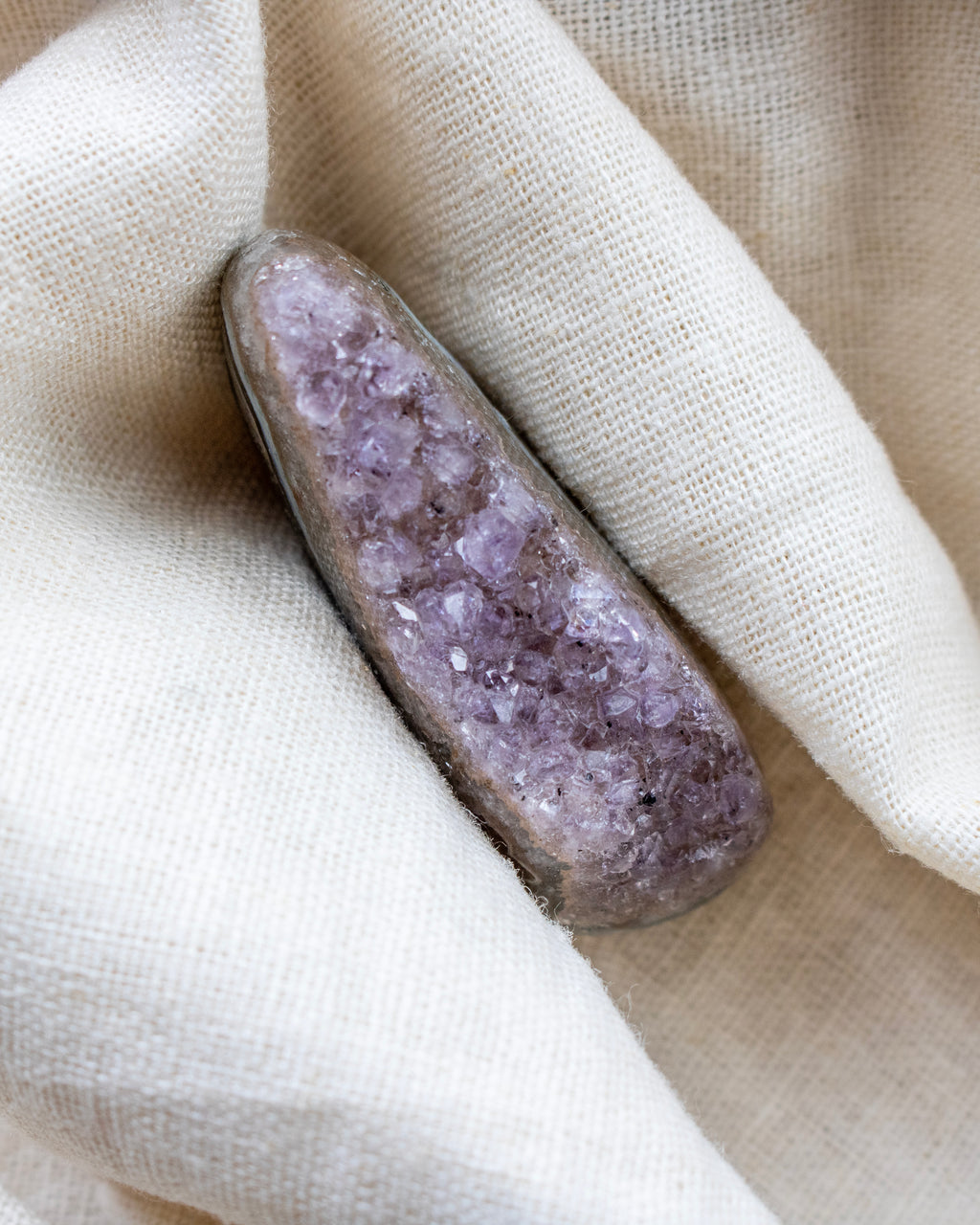 Amethyst crystal on a beige fabric background