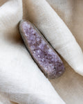 Amethyst crystal on a beige fabric background