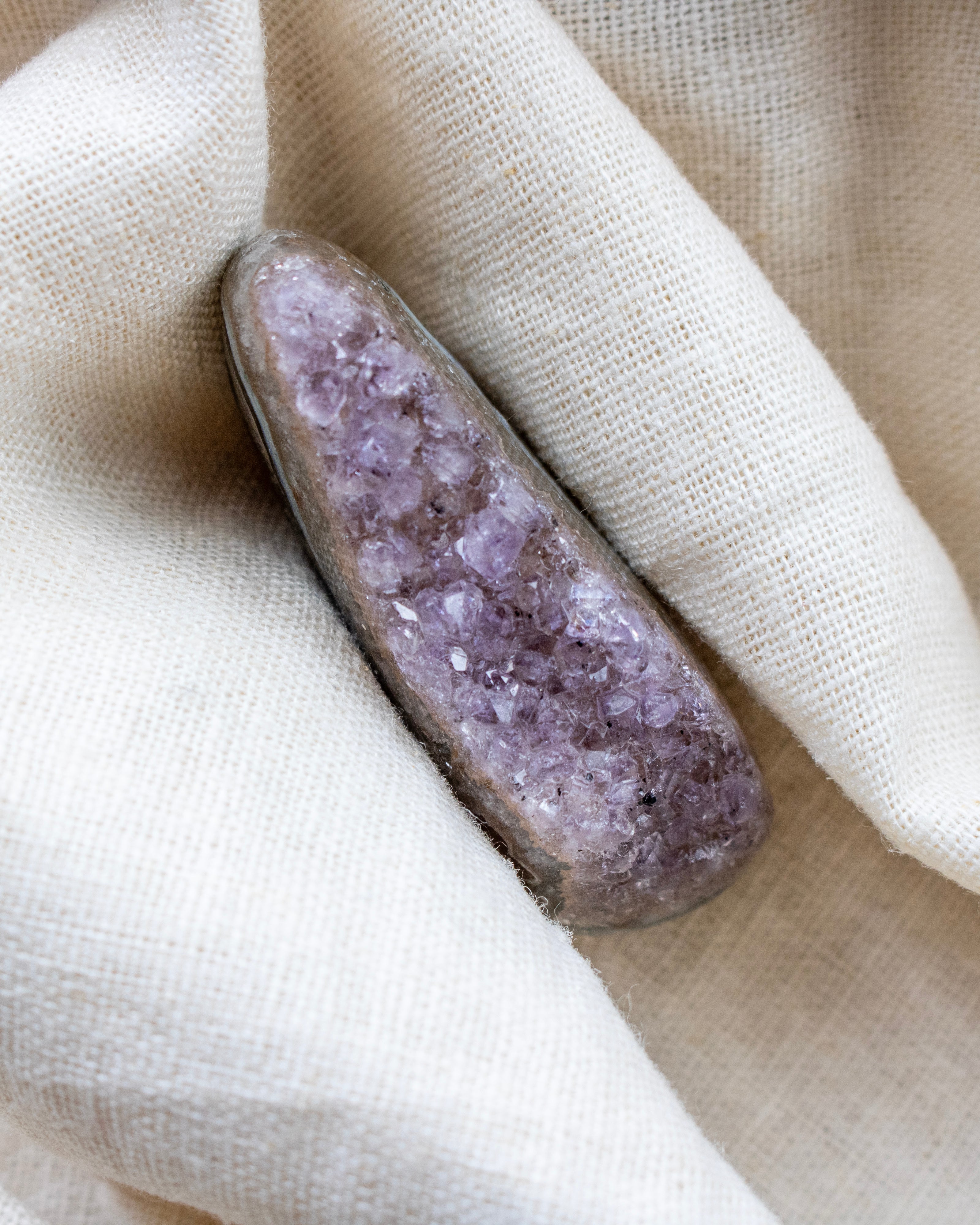 Amethyst crystal on a beige fabric background