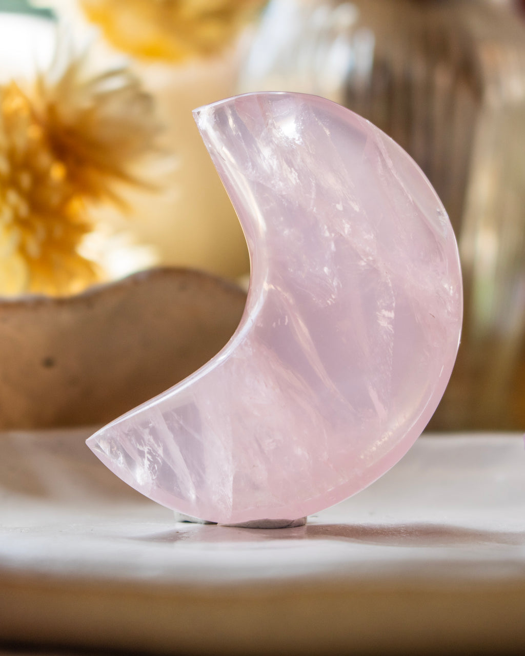 Pink crystal half-moon shape on a neutral background