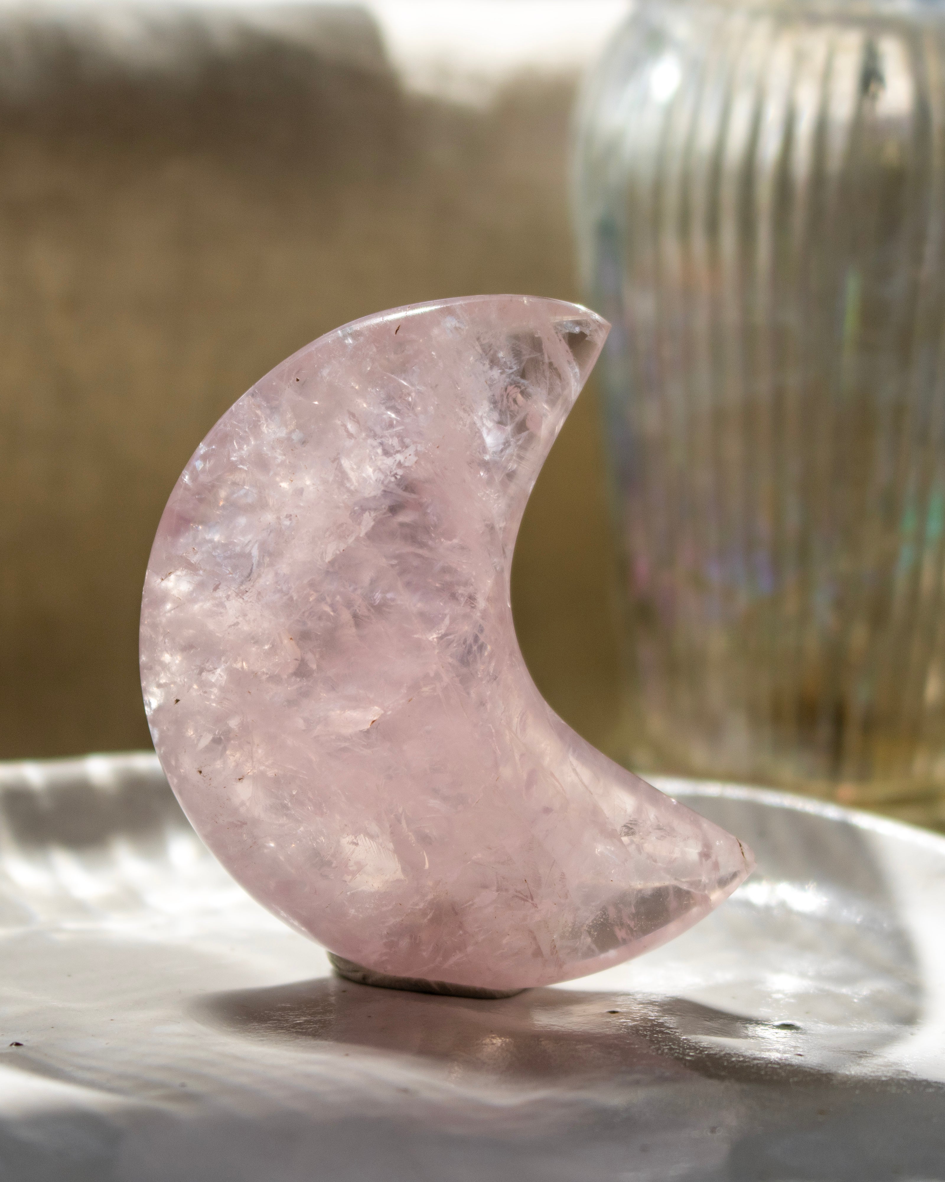 Crystal moon stone on a reflective surface with a blurred background