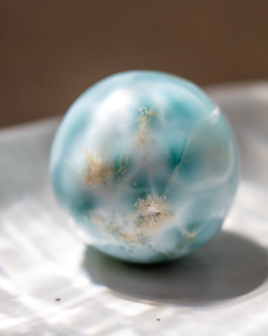 Turquoise marble with white specks on a reflective surface