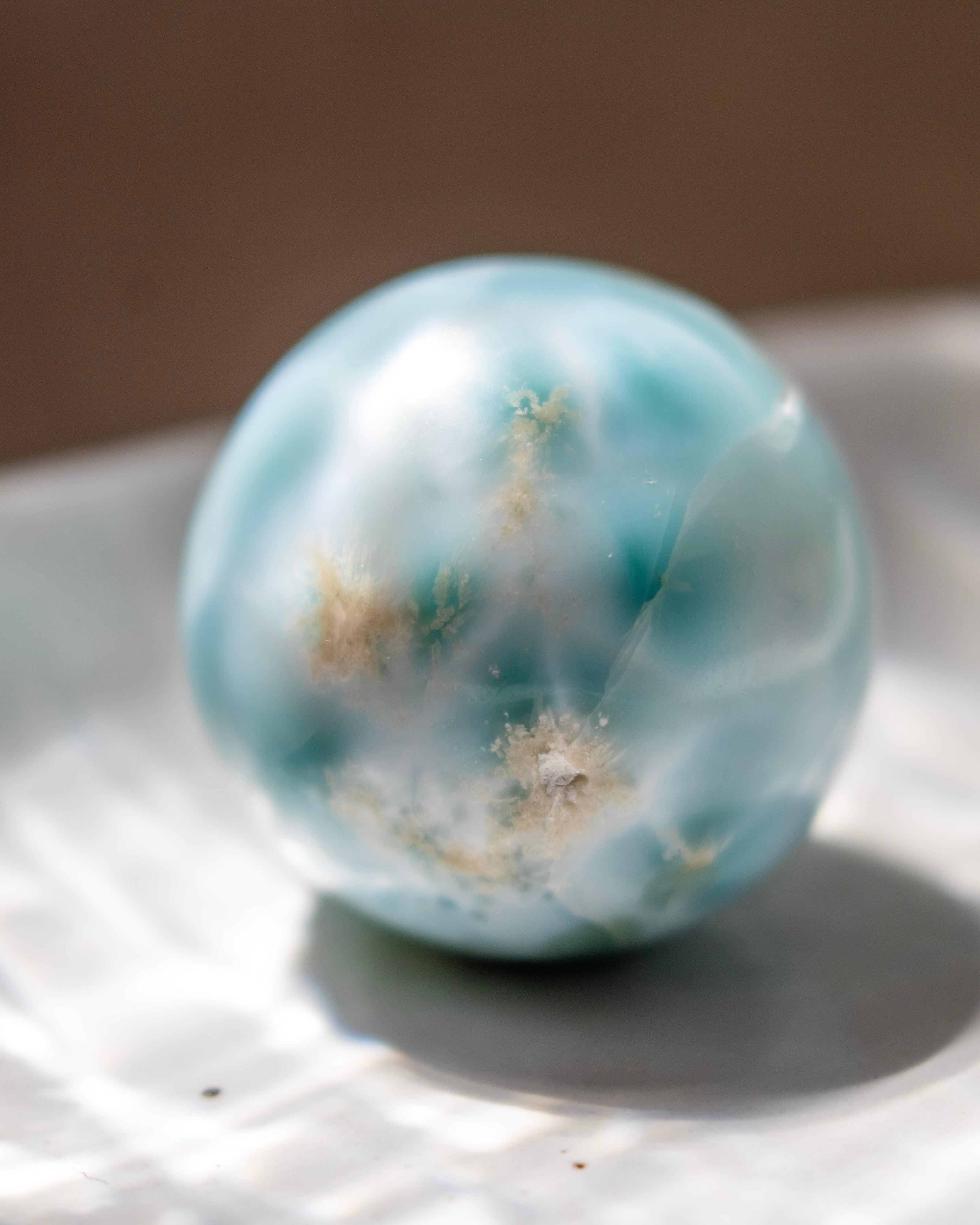 Turquoise marble with white specks on a reflective surface