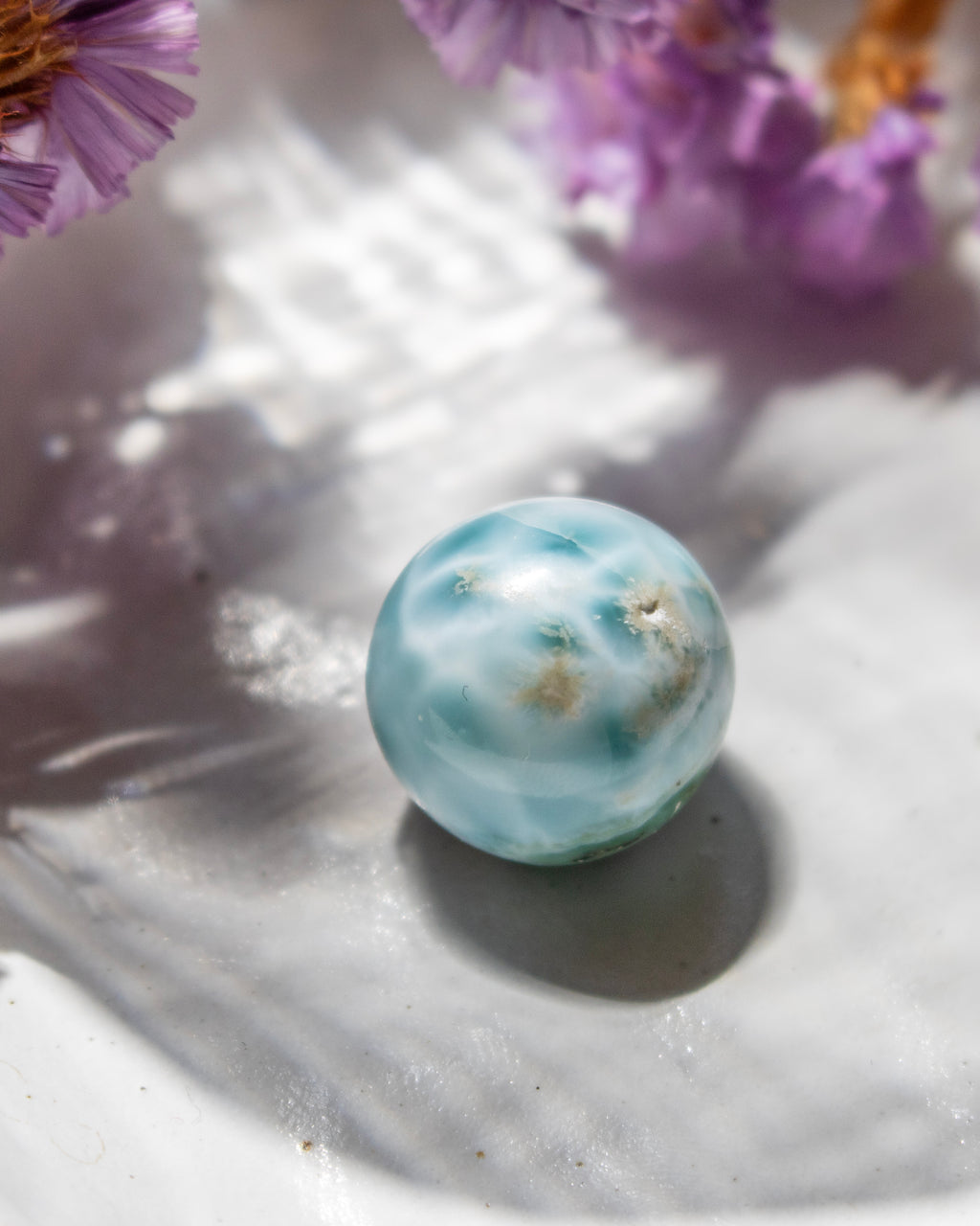 Marble-like sphere with floral elements on a textured surface
