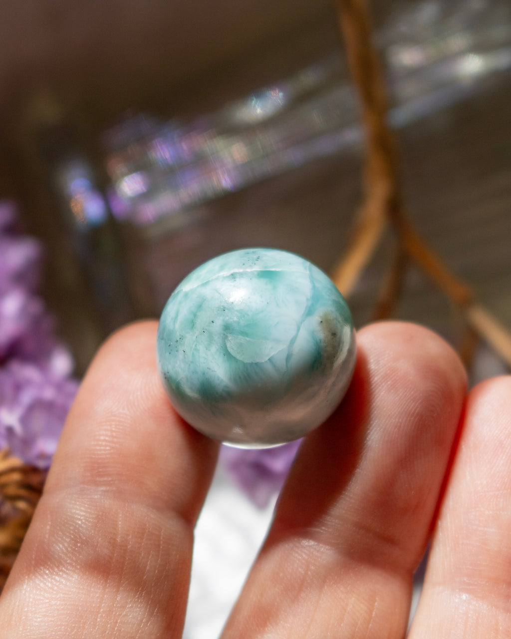 Marbled green and white stone held in a hand with a blurred background