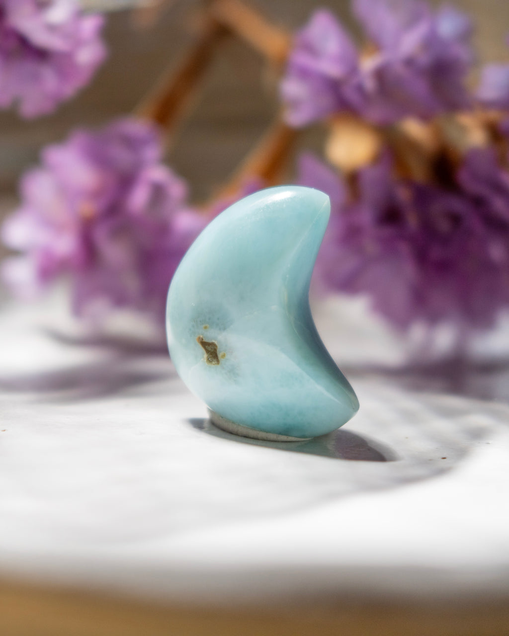 Turquoise stone with a blurred background of purple flowers