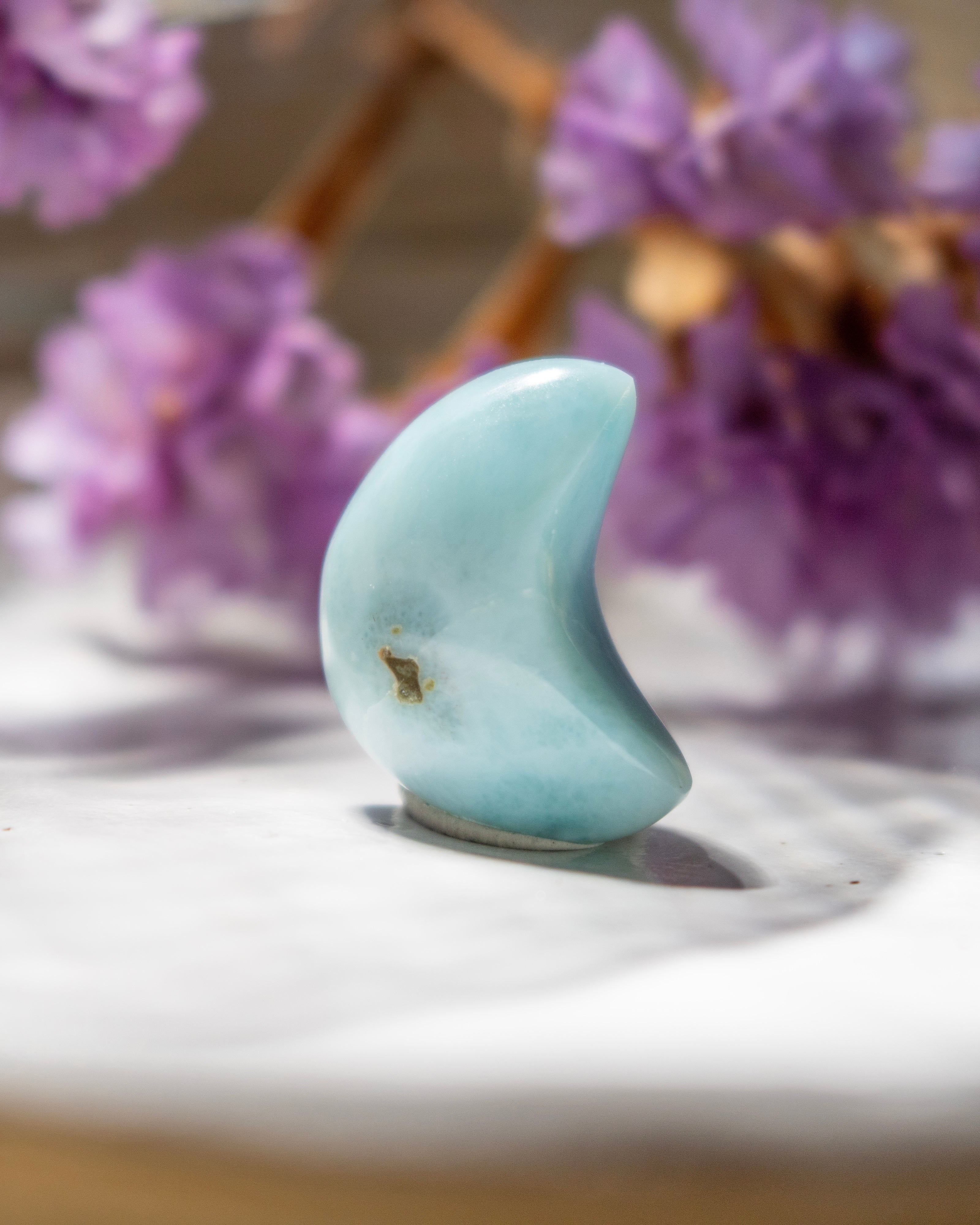 Turquoise stone with a blurred background of purple flowers