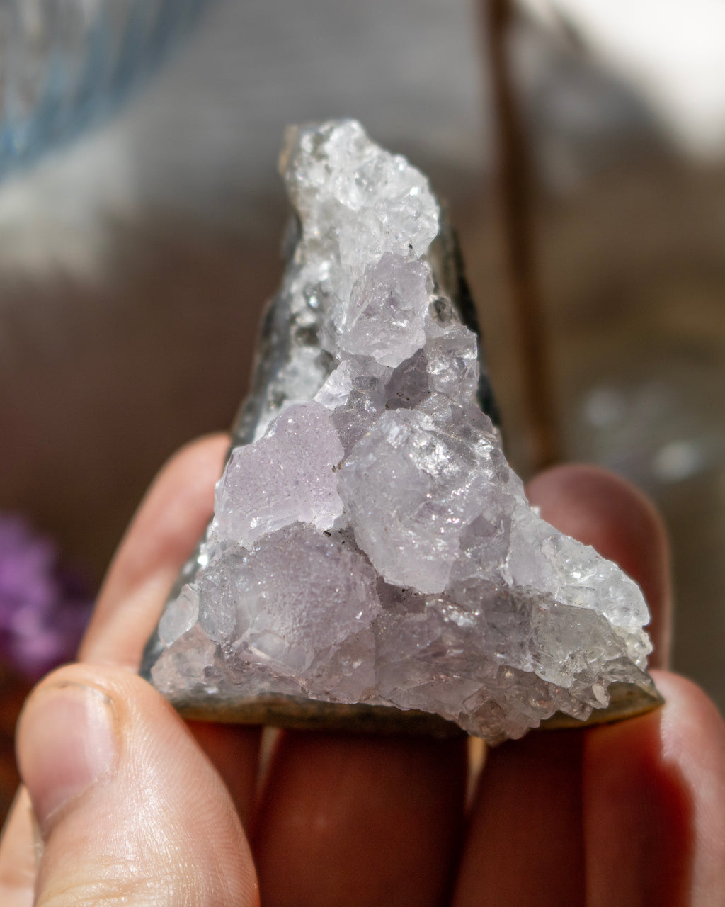 Crystal rock held in a hand with a blurred background
