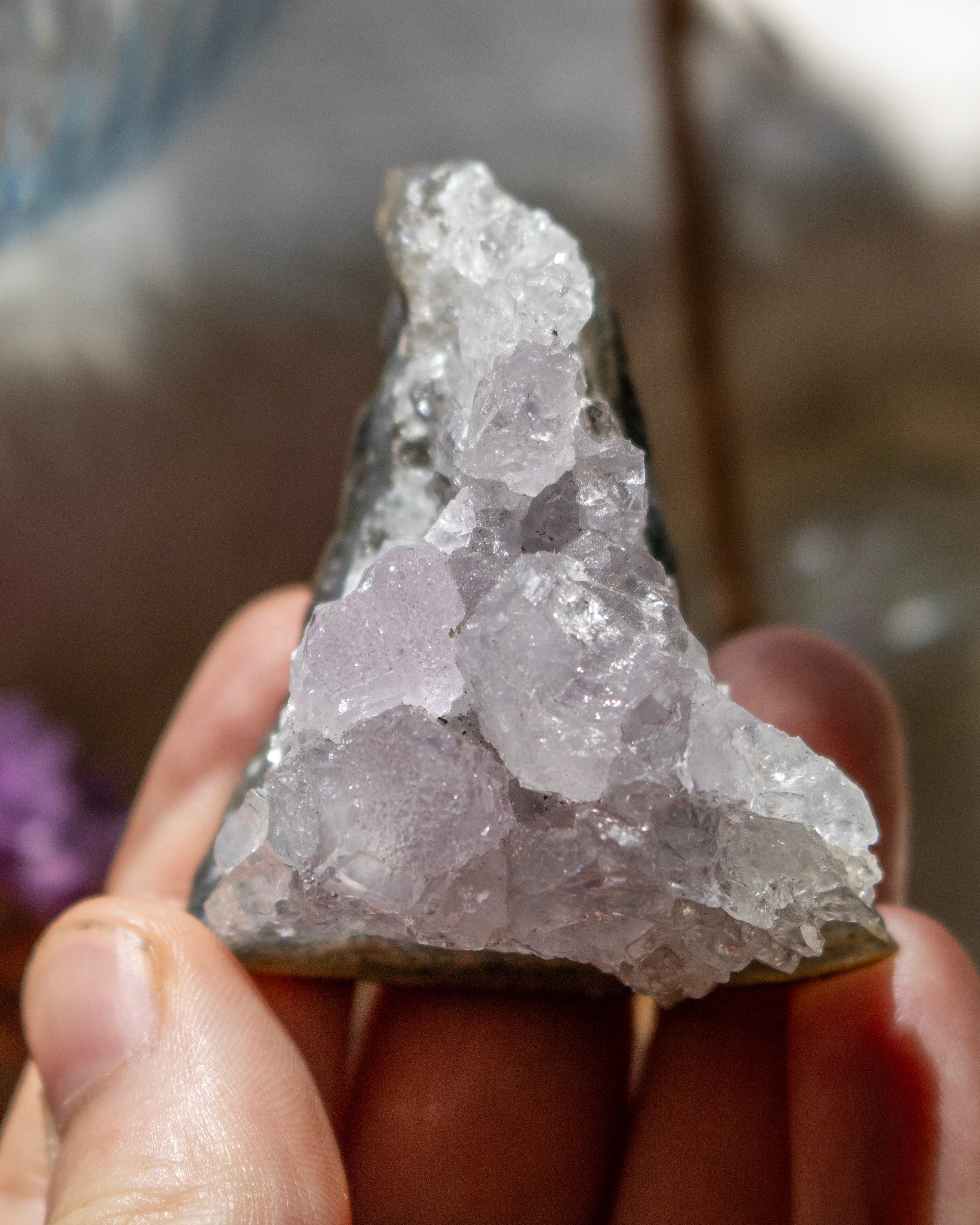Crystal rock held in a hand with a blurred background