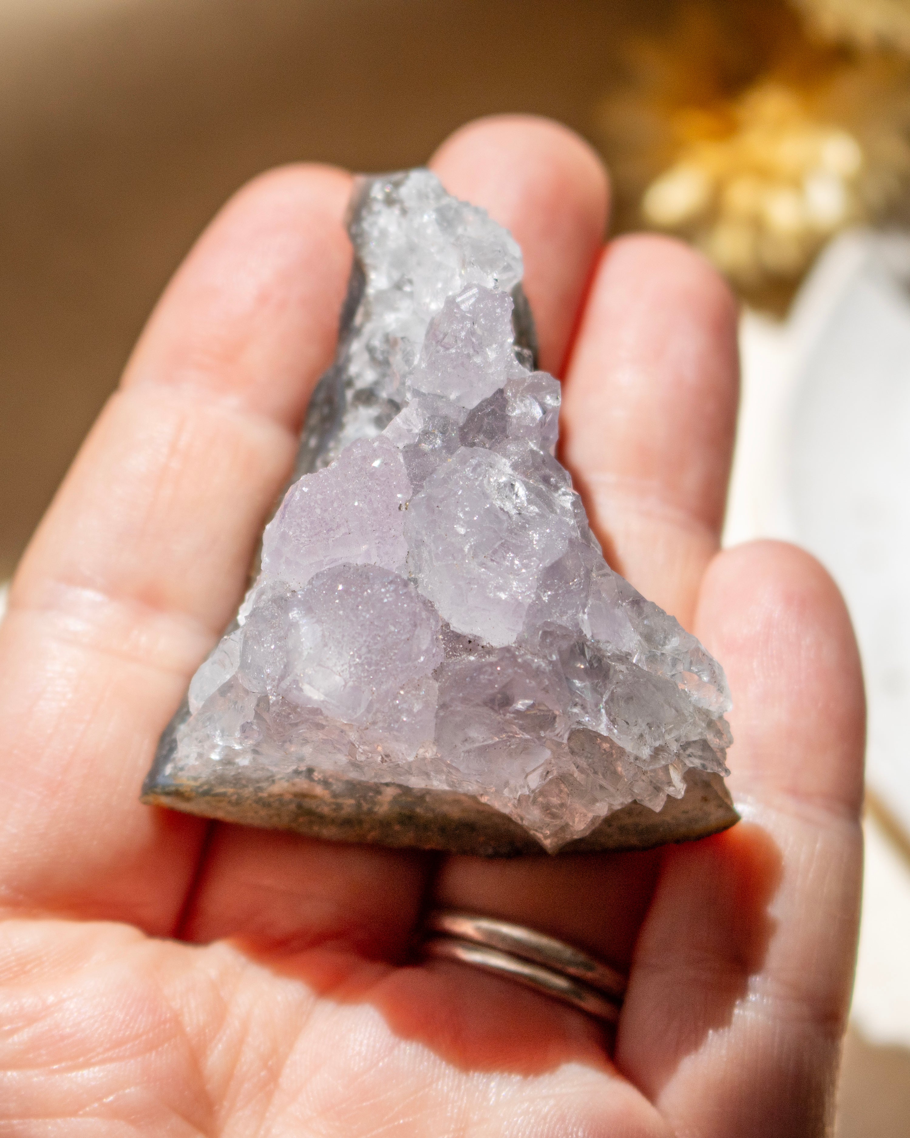 Hand holding a crystal rock with a blurred background