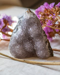 Crystal rock with pink flowers on a textured surface