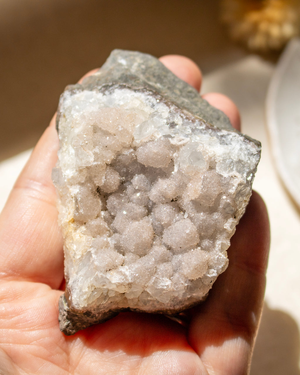 Hand holding a crystal rock with a blurred background