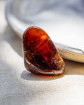 Close-up of a amber stone on a textured fabric background