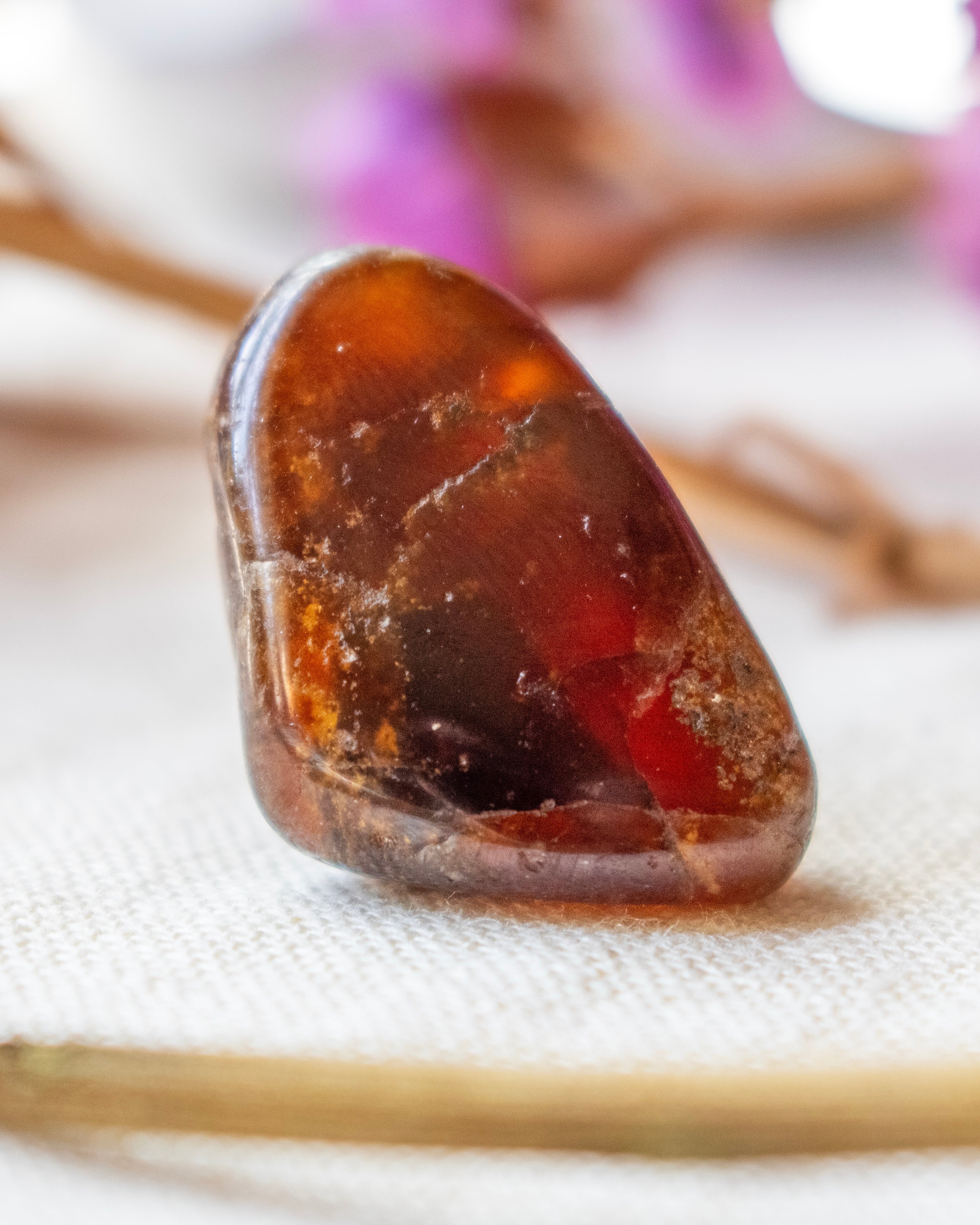 Close-up of a rough amber stone on a textured surface with blurred background